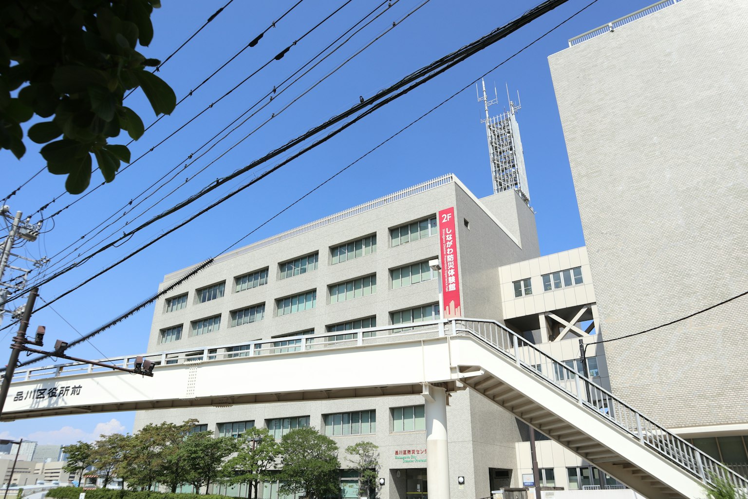 Bâtiment moderne avec un pont piéton sous un ciel bleu clair