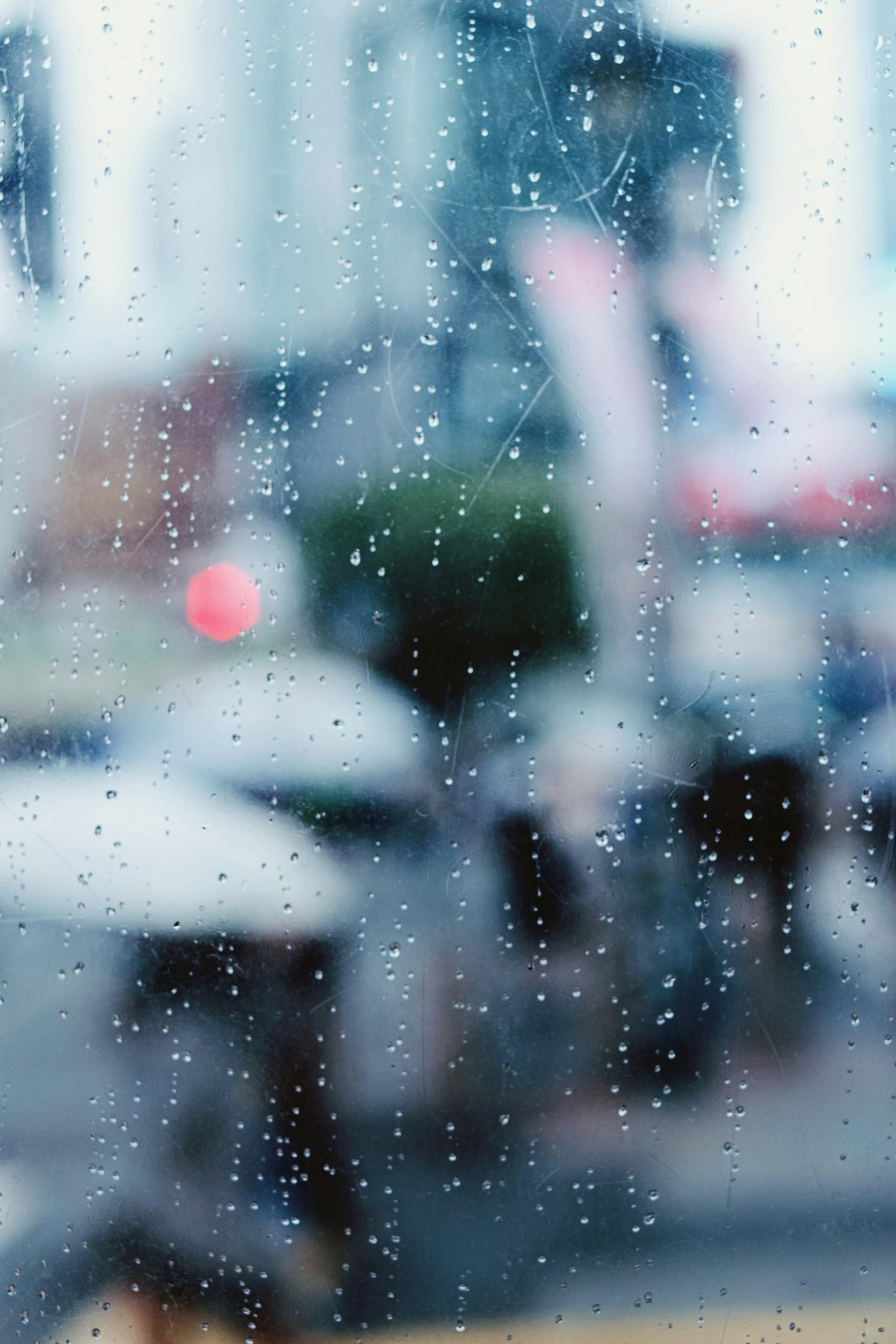 วิวเมืองผ่านหน้าต่างที่เปียกฝนพร้อมกับหยดน้ำ