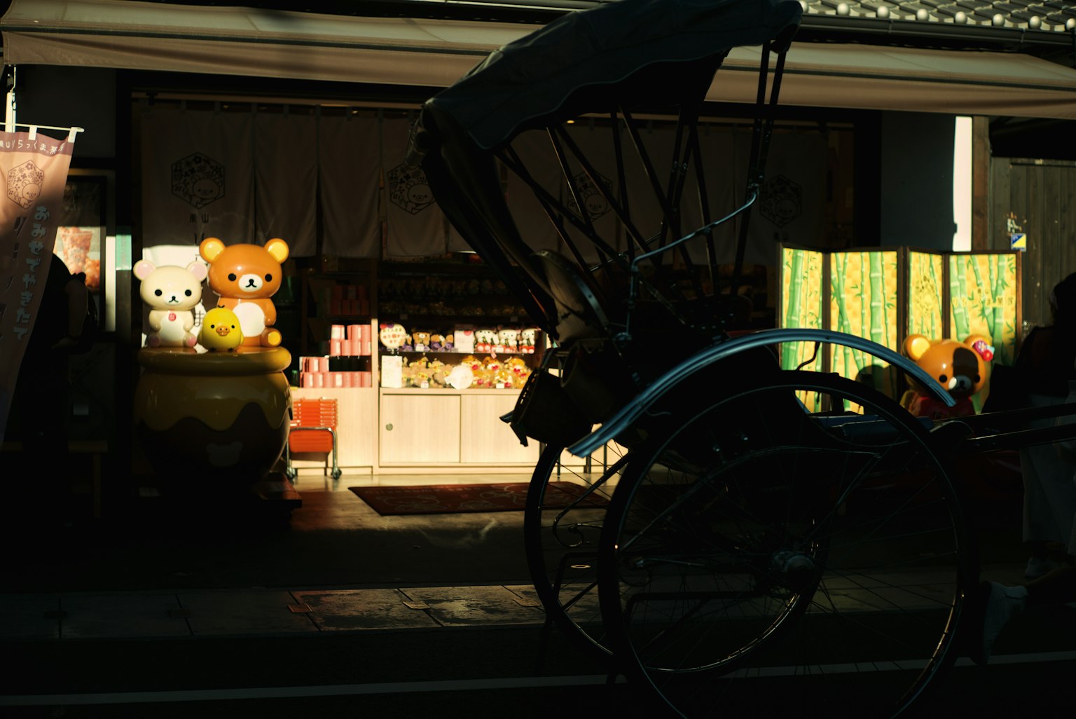 商店外觀,展示著Rilakkuma和Korilakkuma毛絨玩具以及前景中的人力車