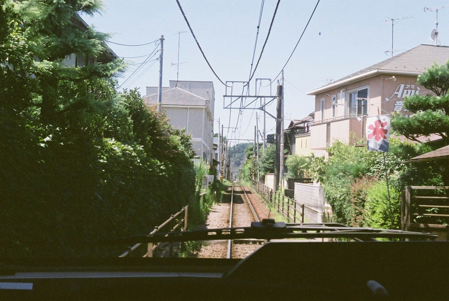沿铁路轨道的风景，绿树和房屋