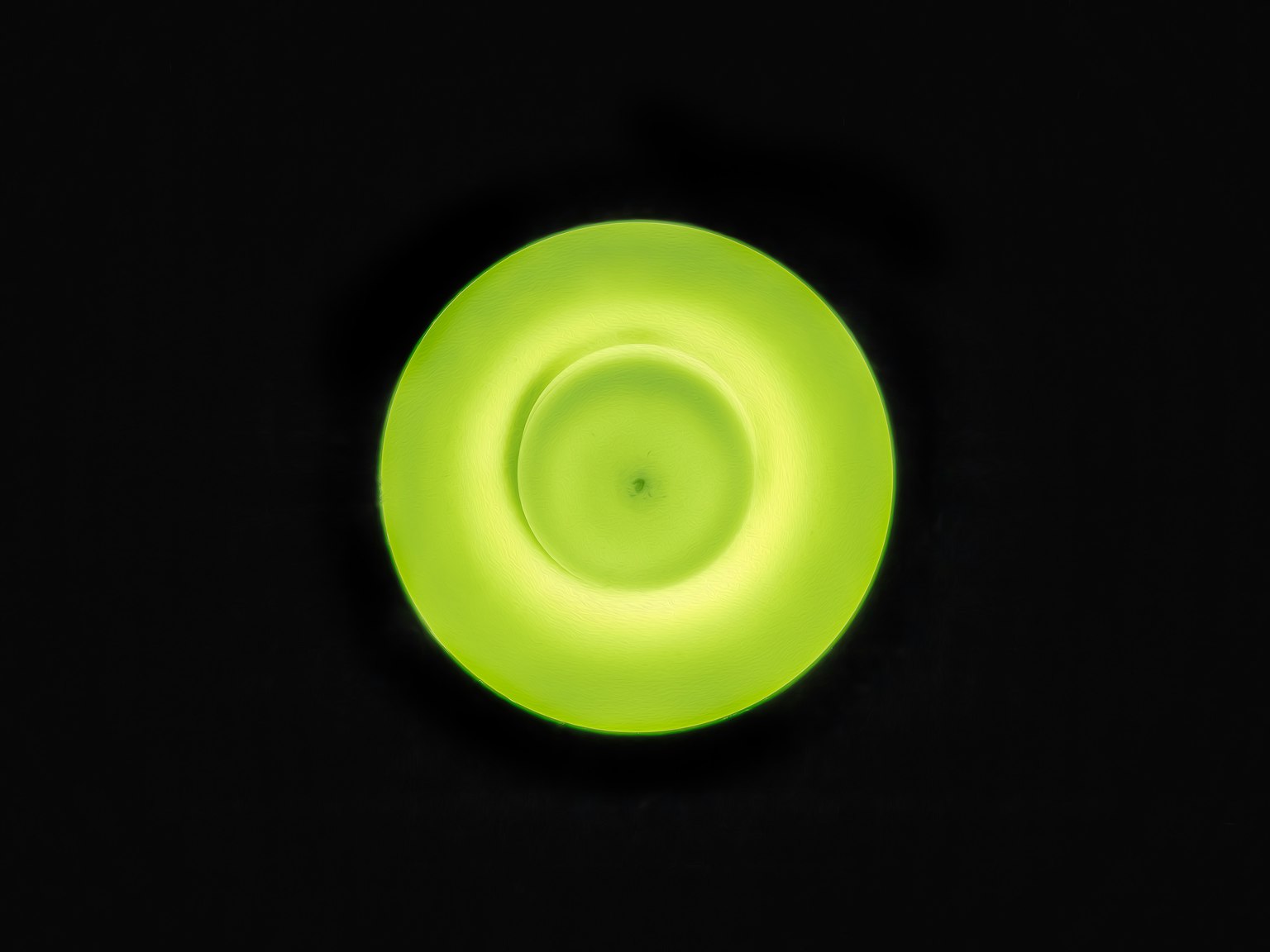 วัตถุวงกลมสีเขียวสดใสบนพื้นหลังสีดำ