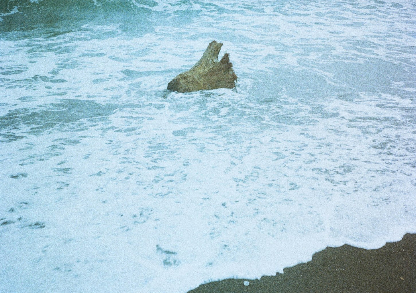 波打ち際に浮かぶ岩と砕ける海面