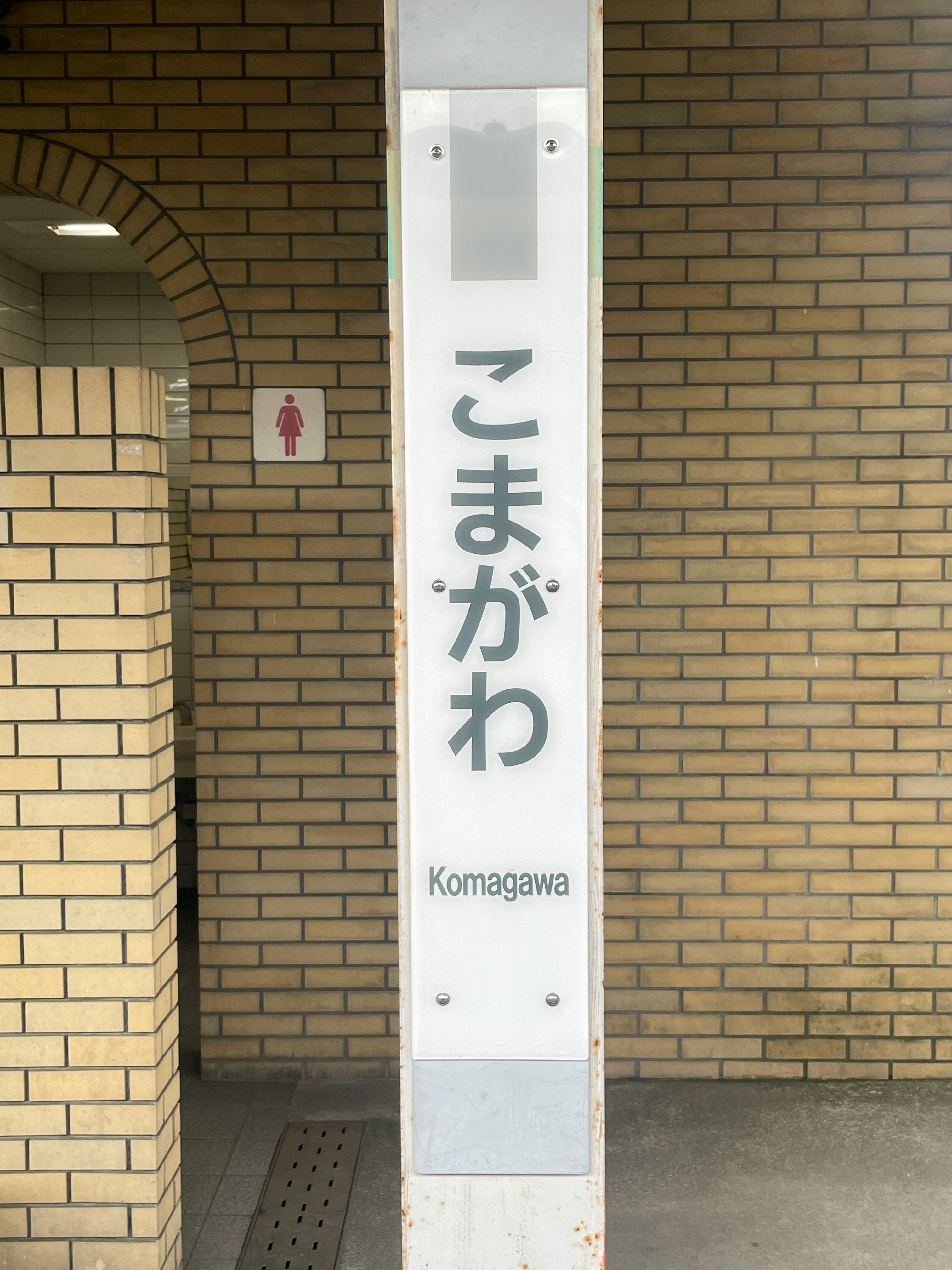 磚拱通道裡的「こまがわ／Komagawa」指示牌影像