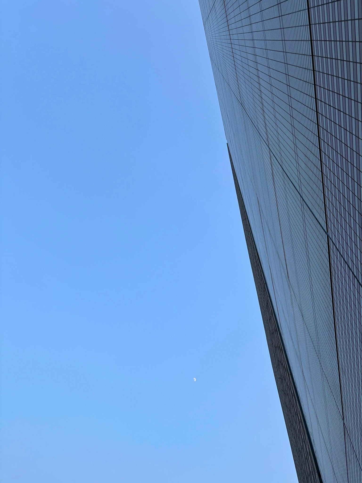 Bild zeigt ein Hochhaus vor einem klaren blauen Himmel