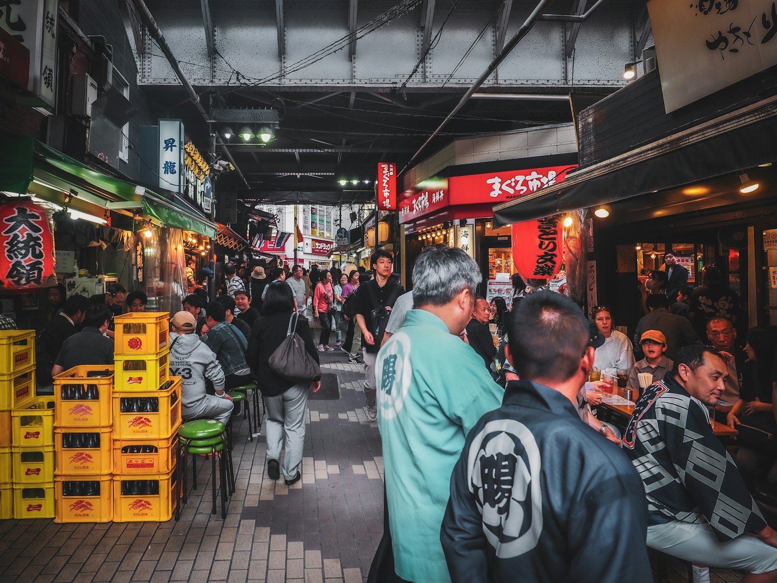 일본 길거리 음식 골목의 분주한 풍경 사람들은 식사를 즐기고 노란 상자가 쌓여 있다