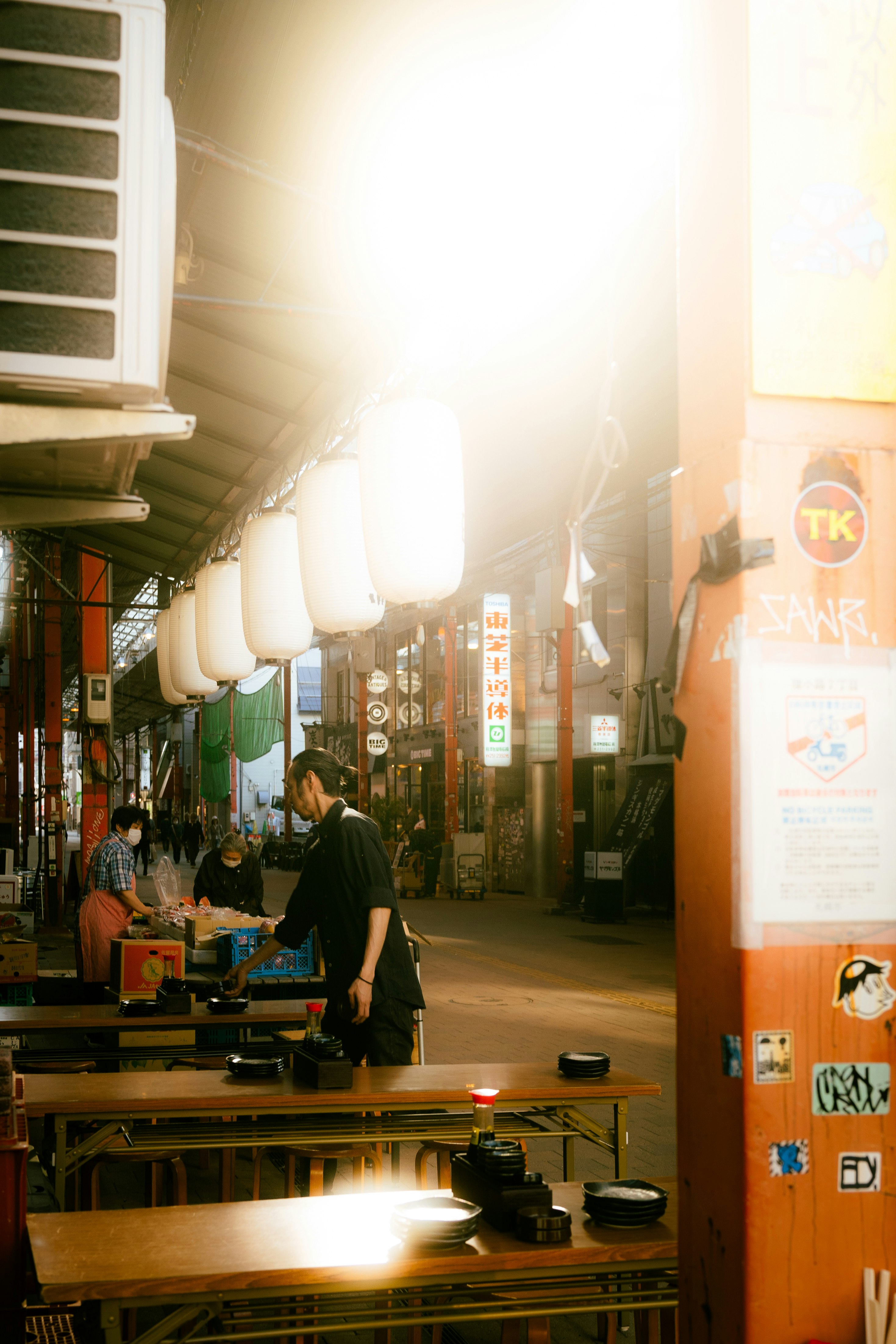 evening street market counter with hanging lanterns in a narrow alley