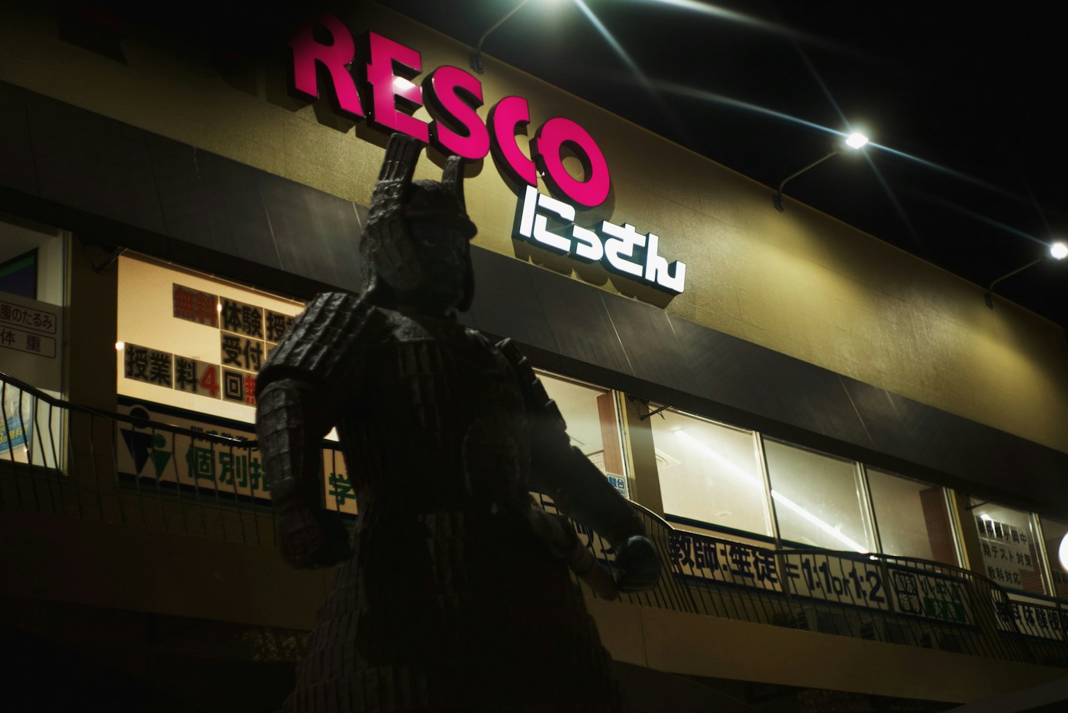 รูปปั้นซามูไรขนาดใหญ่หน้าป้าย Resco ในตอนกลางคืน