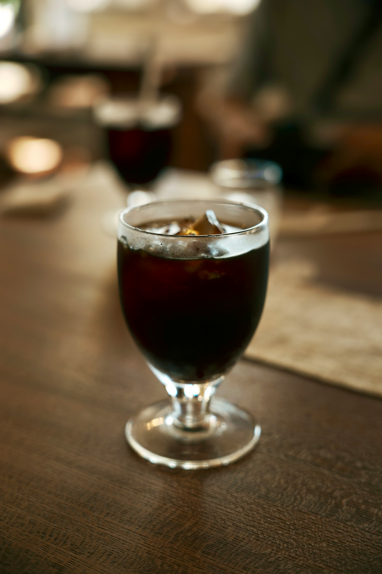 Segelas kopi es di atas meja kayu