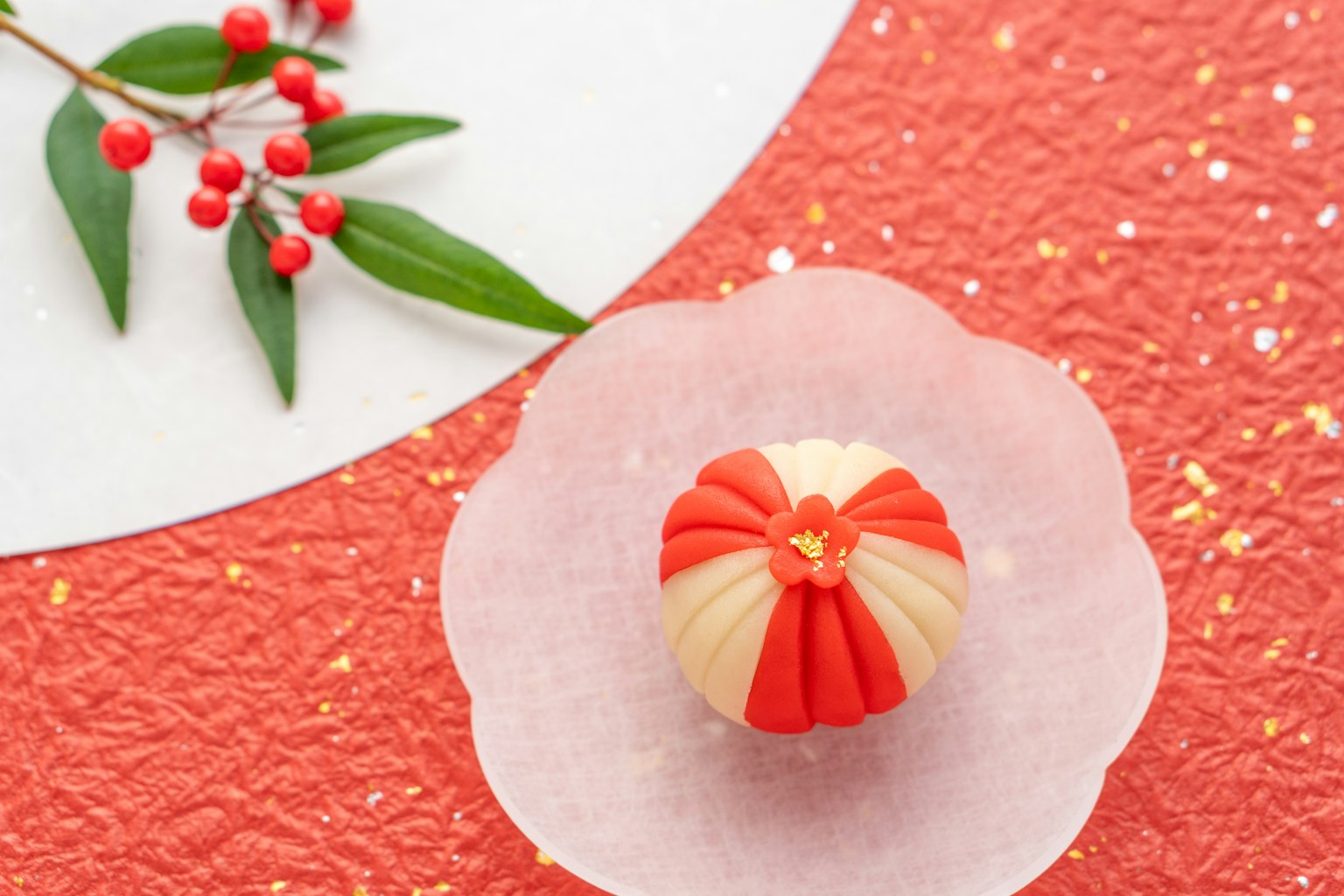Una colorida confitería japonesa en un plato en forma de pétalo con diseño rojo y blanco