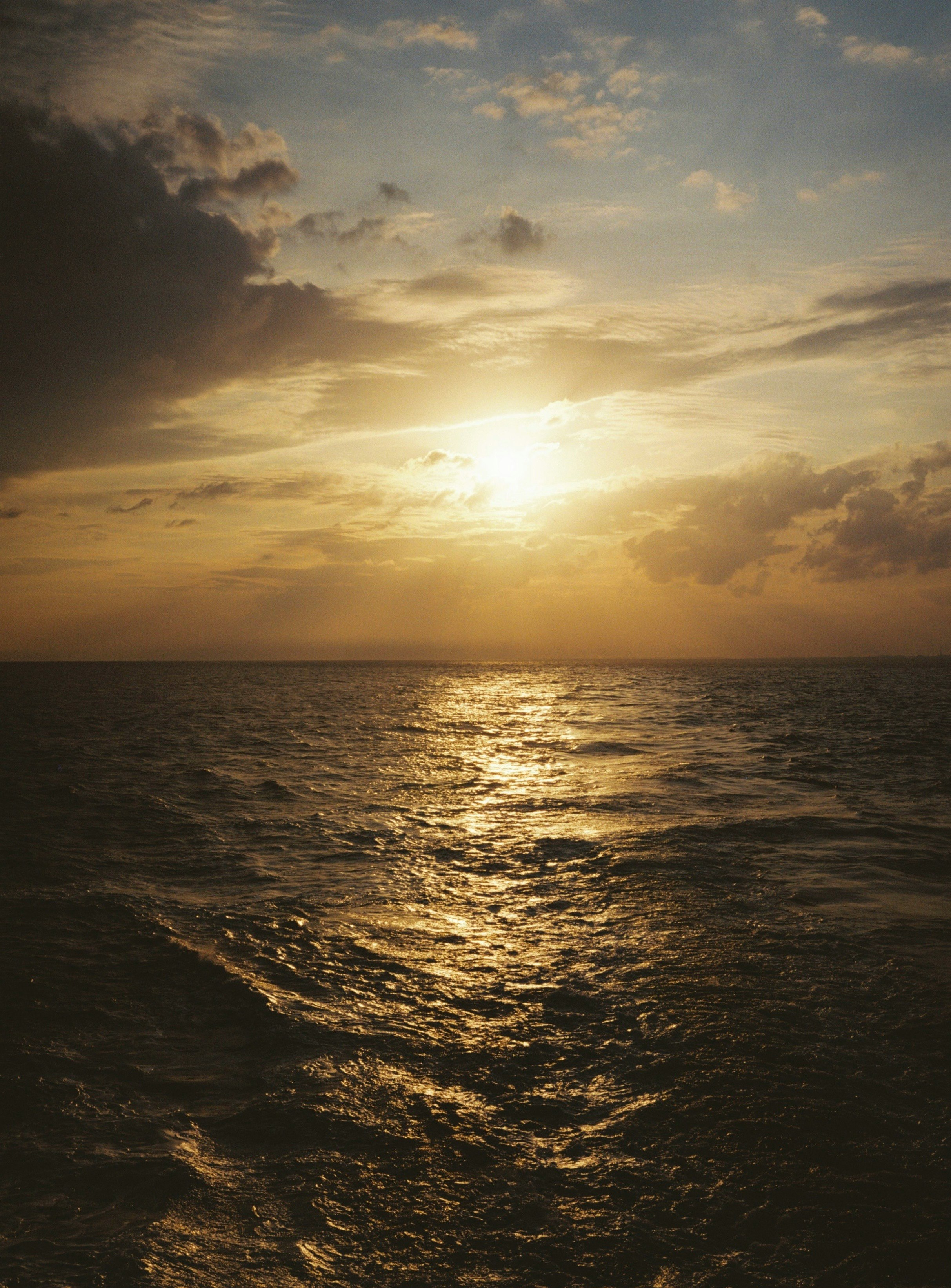 水平線に沈む夕日と雲の海景