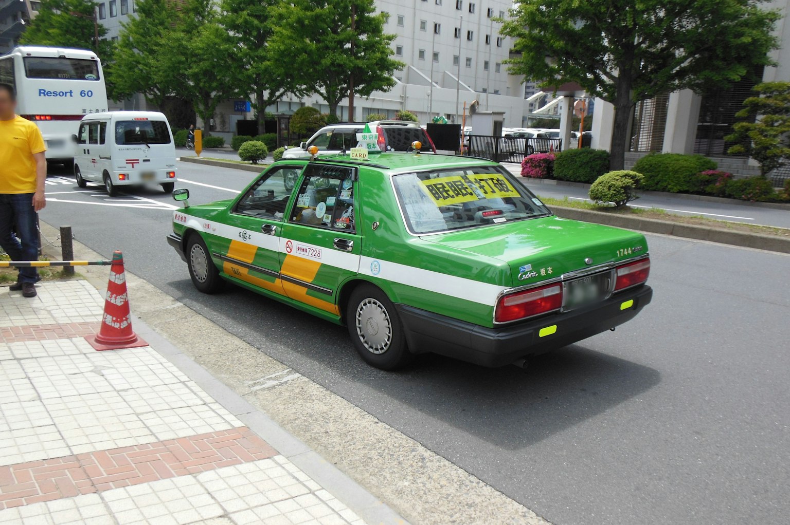 Un taxi vert circulant dans la rue
