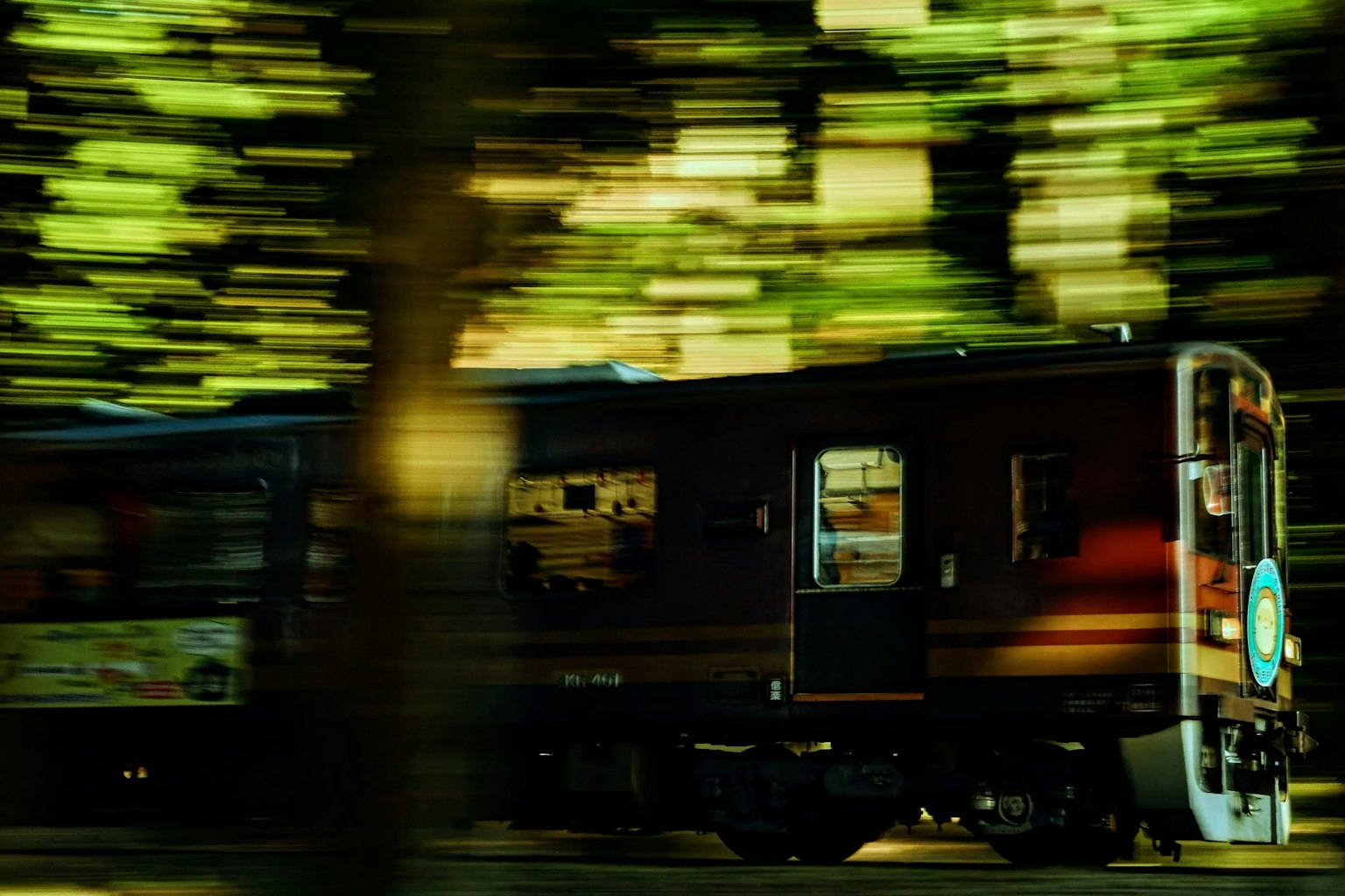 Vista laterale di un treno in movimento con sfondo verde sfocato