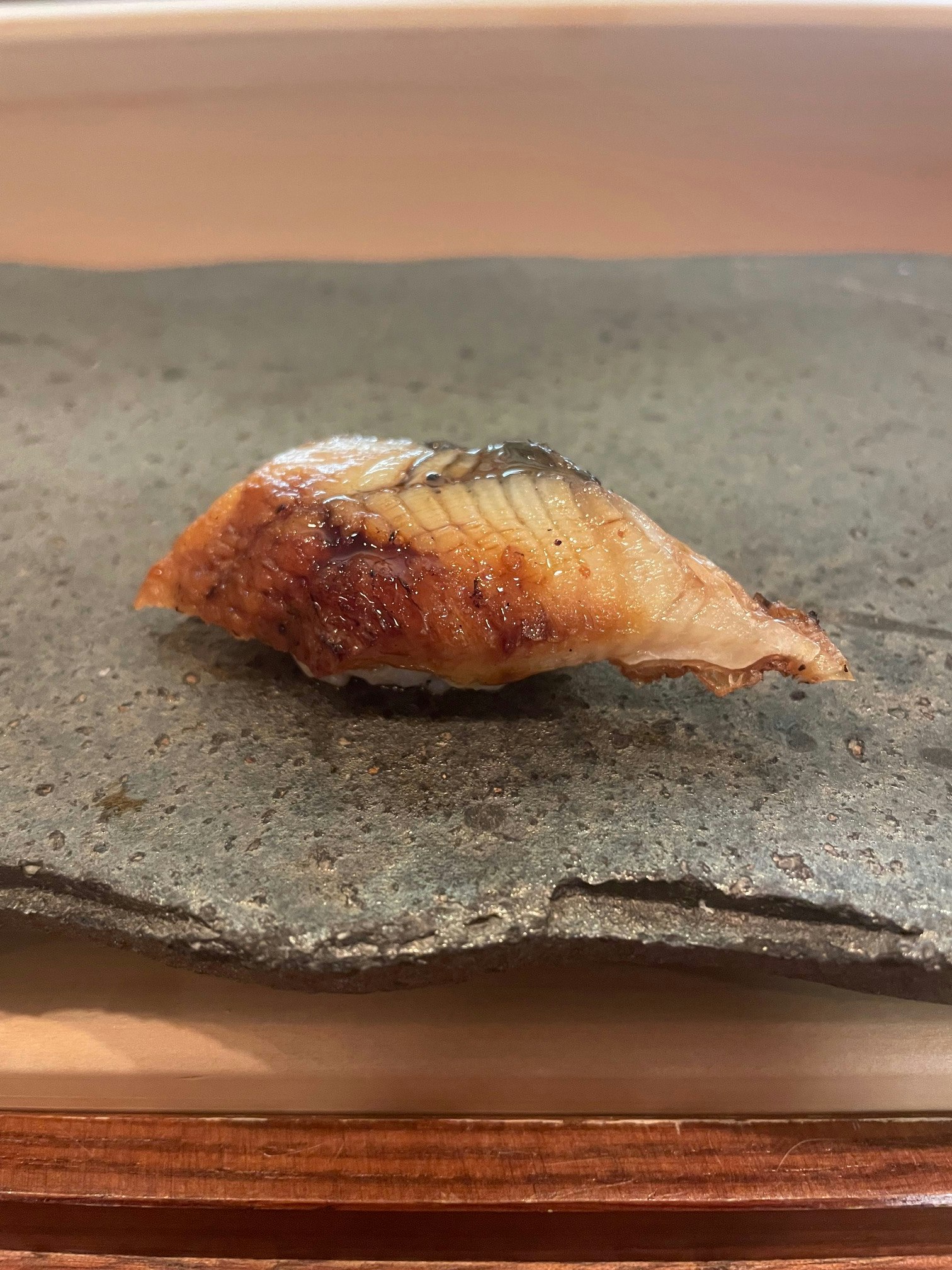 nigiri di mollusco grigliato su superficie in pietra