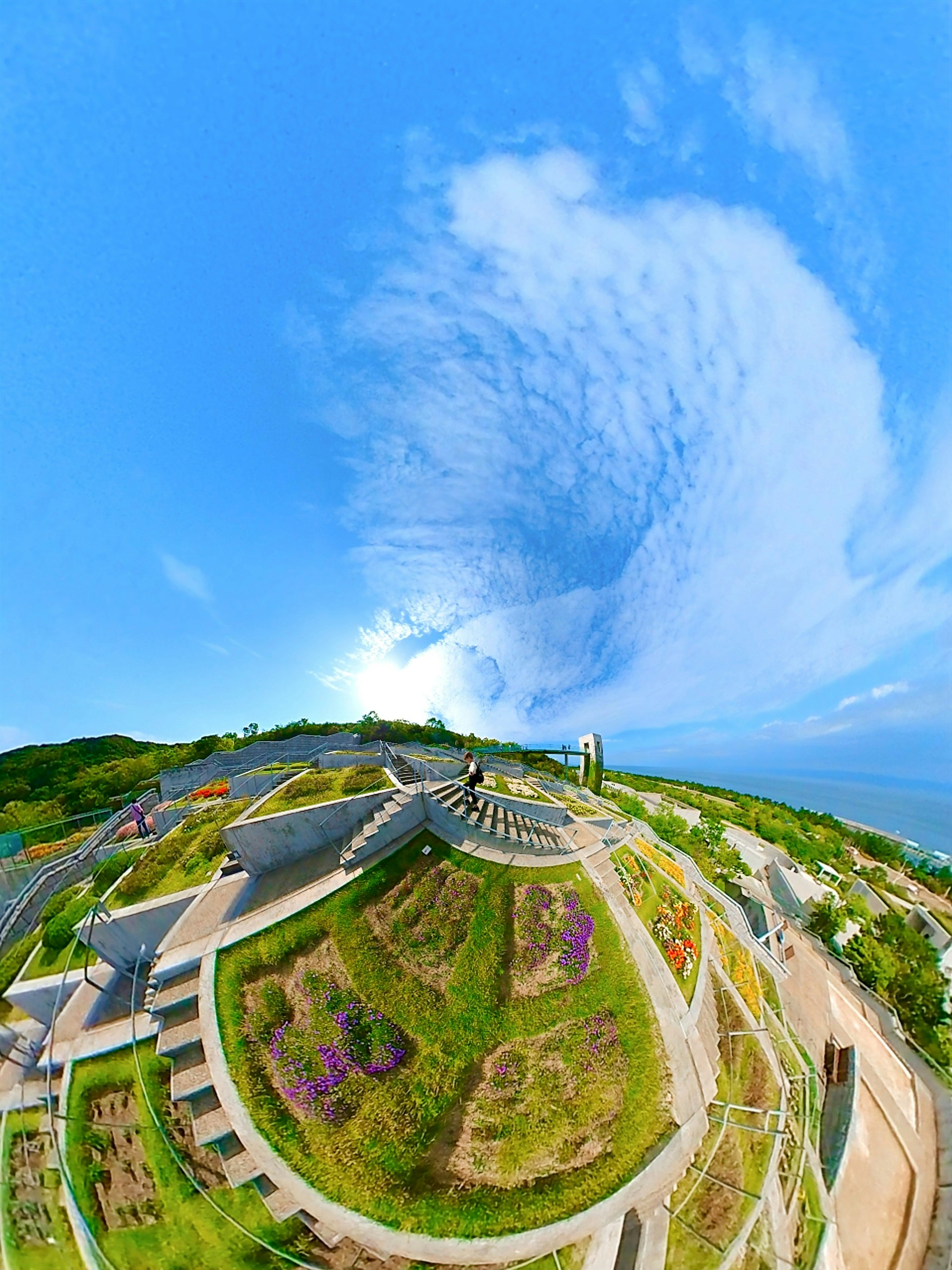 Terrazza panoramica e giardino erboso su una collina sotto un cielo azzurro