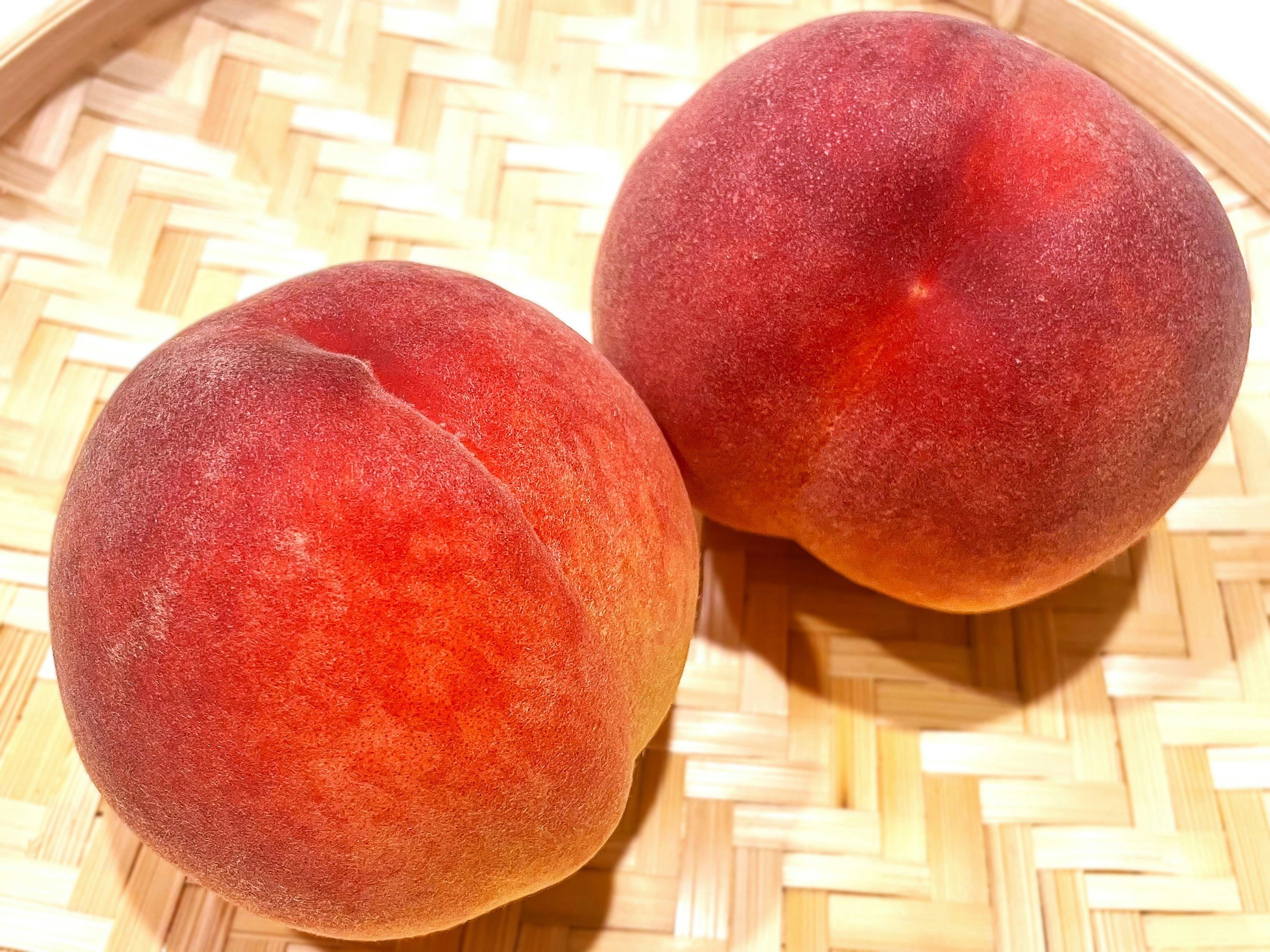 Fresh peaches in a woven bamboo tray