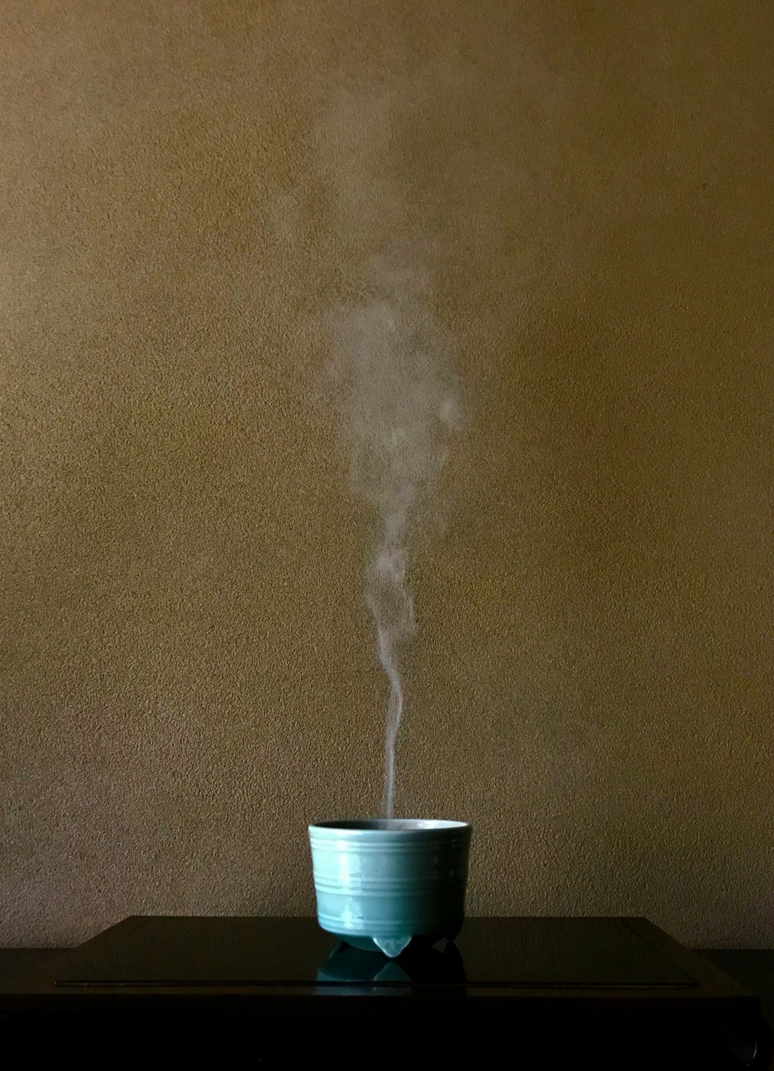 Steaming blue ceramic bowl placed on a black table