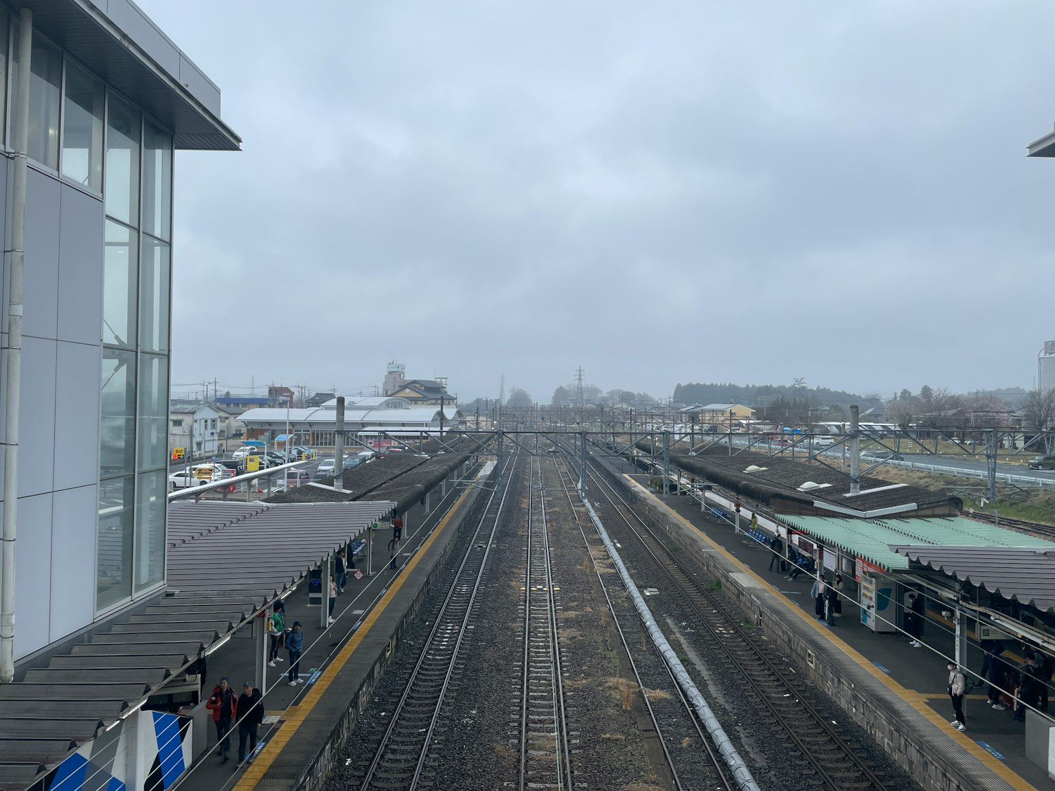 Pemandangan stasiun kereta dengan rel di bawah langit mendung