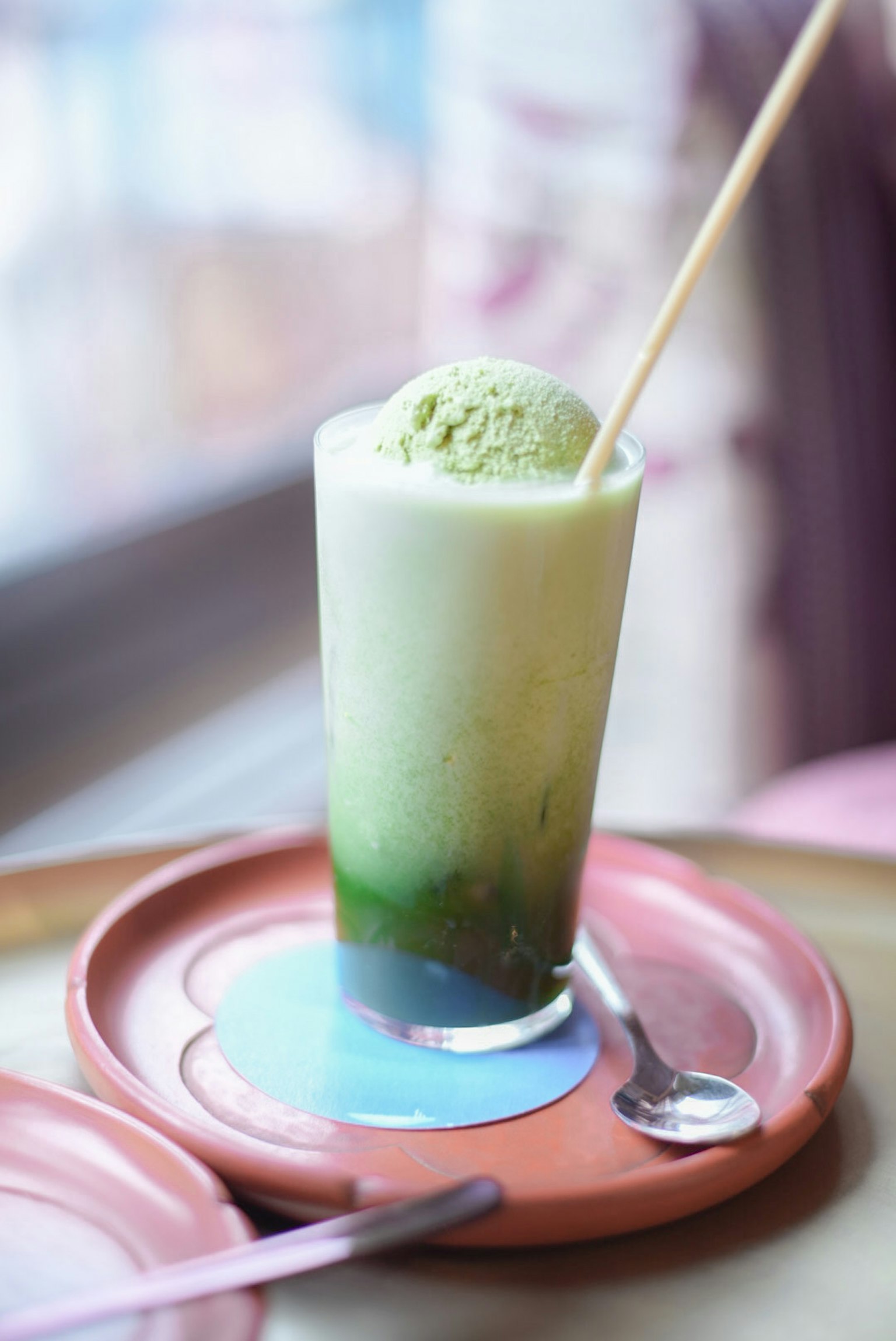 Một đồ uống trà xanh có kem trà xanh trên đỉnh trong cốc