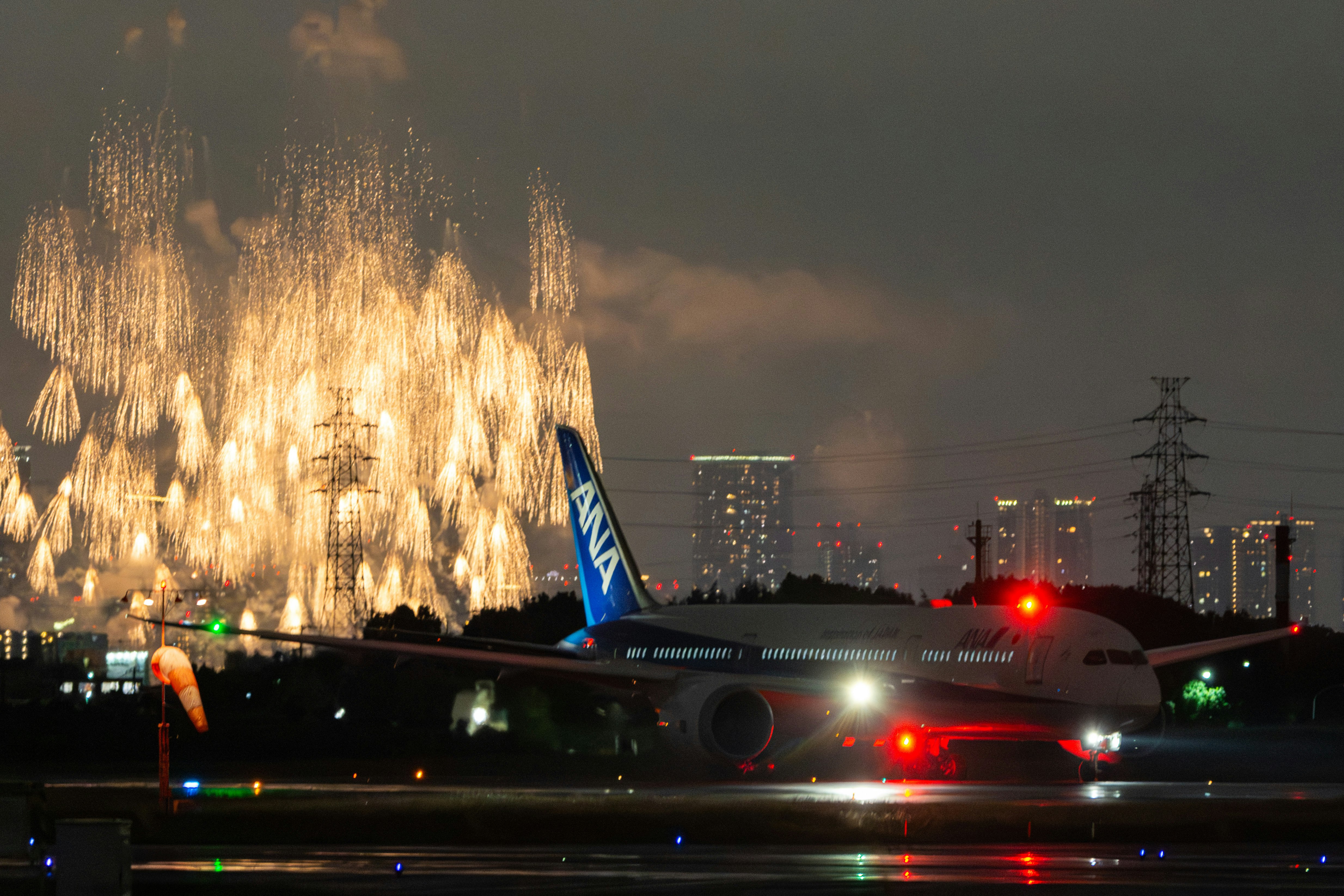 大雨の花火と伊丹空港の飛行機の地面反射