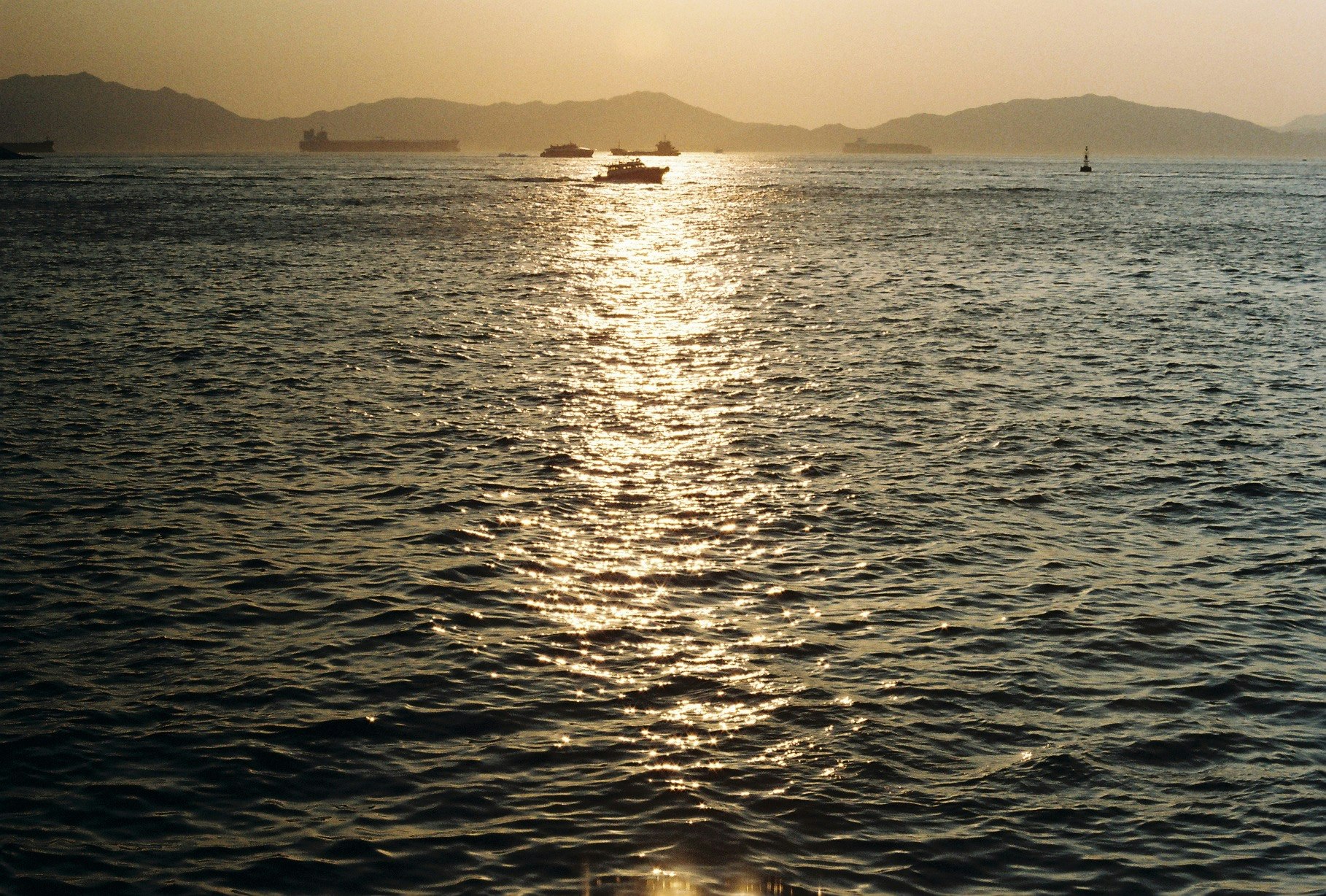 夕日に照らされた海面と沖合の小舟