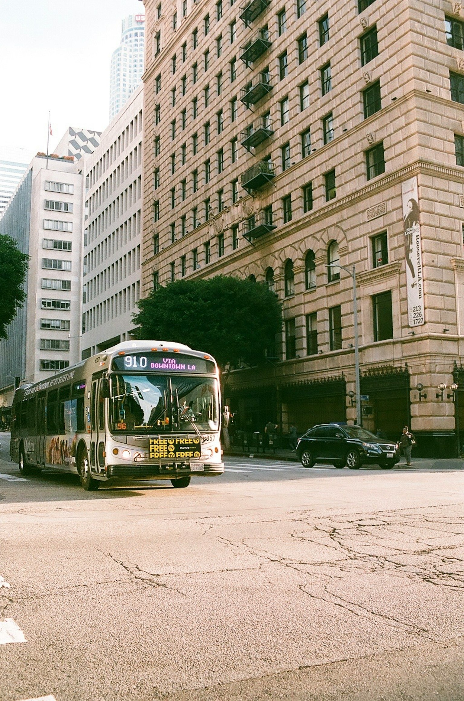 Autobús urbano girando en la esquina con un edificio histórico de fondo
