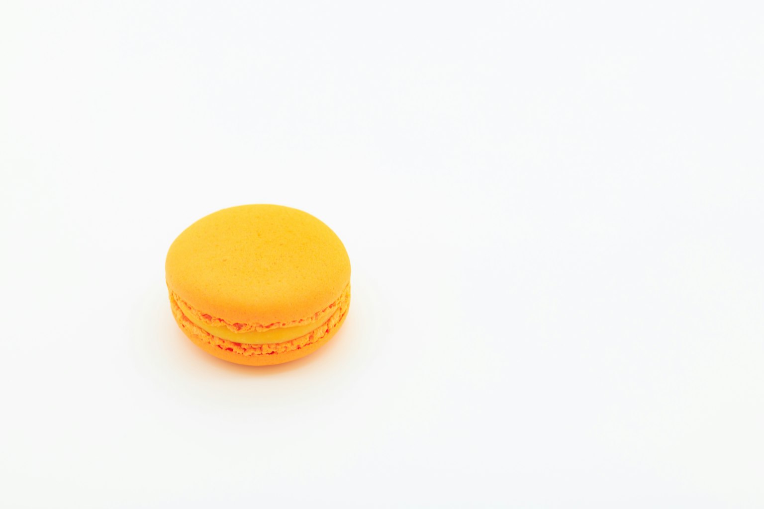 Un macaron arancione su uno sfondo bianco