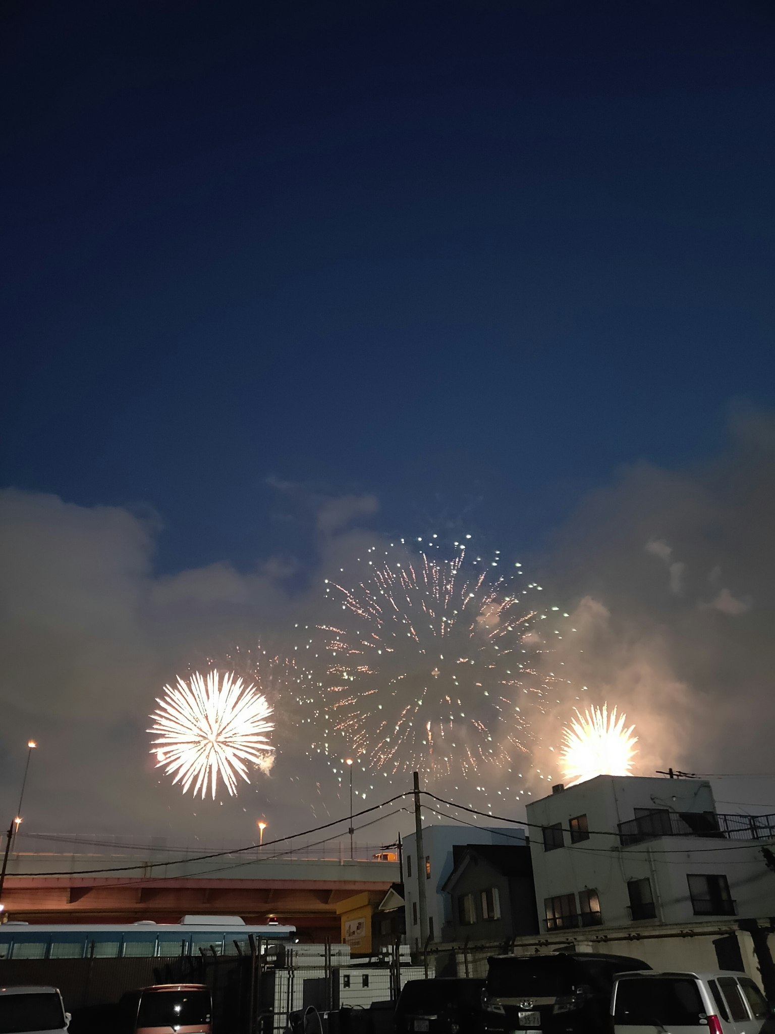 Feuerwerke explodieren am Nachthimmel und erhellen die Wolken