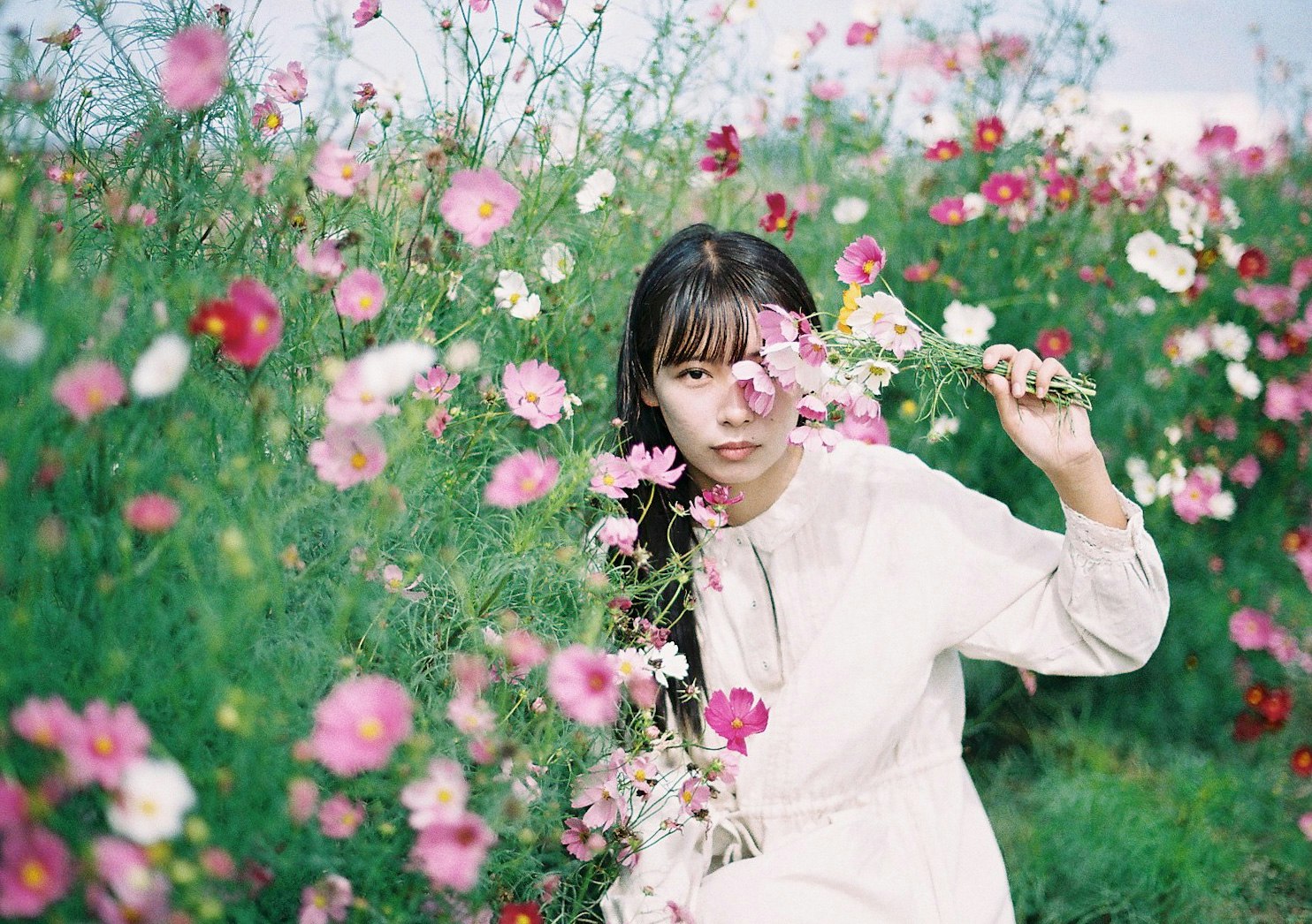 花畑で花冠を手にする女性
