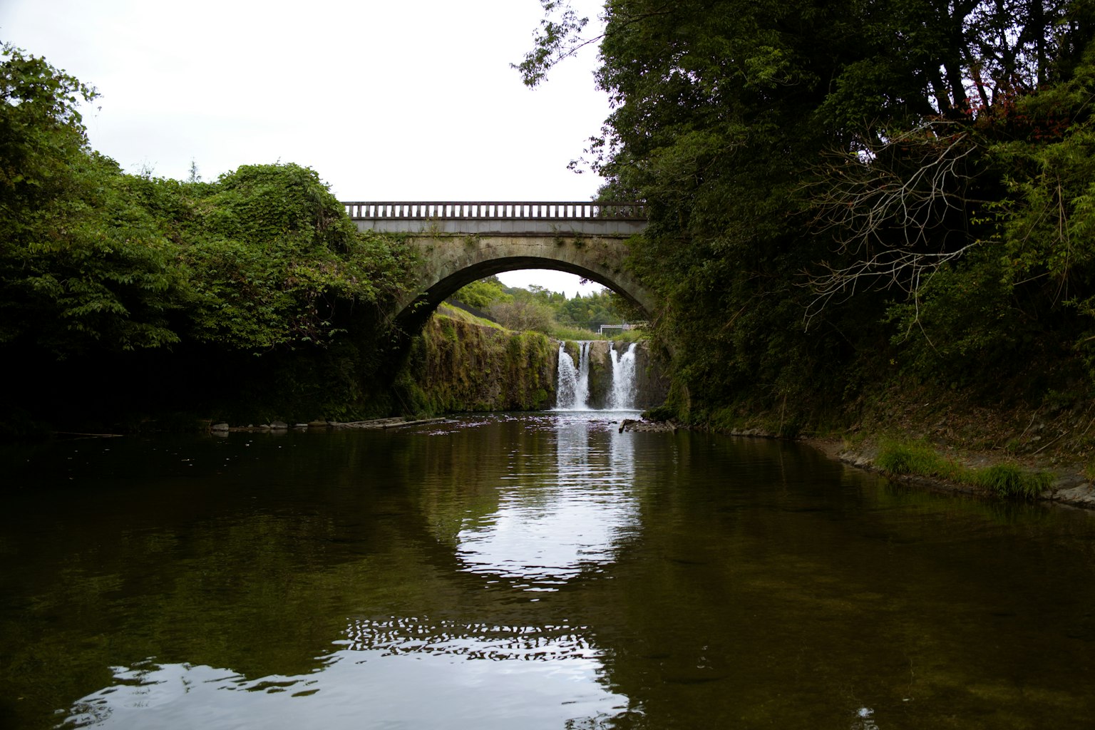 Paysage de rivière serein avec un pont et des chutes d'eau