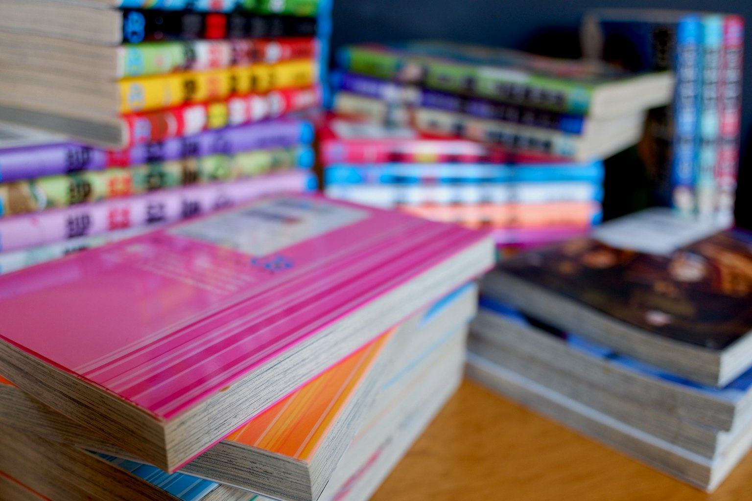 กองหนังสือหลากสีสันที่มีปกและขนาดต่างกัน