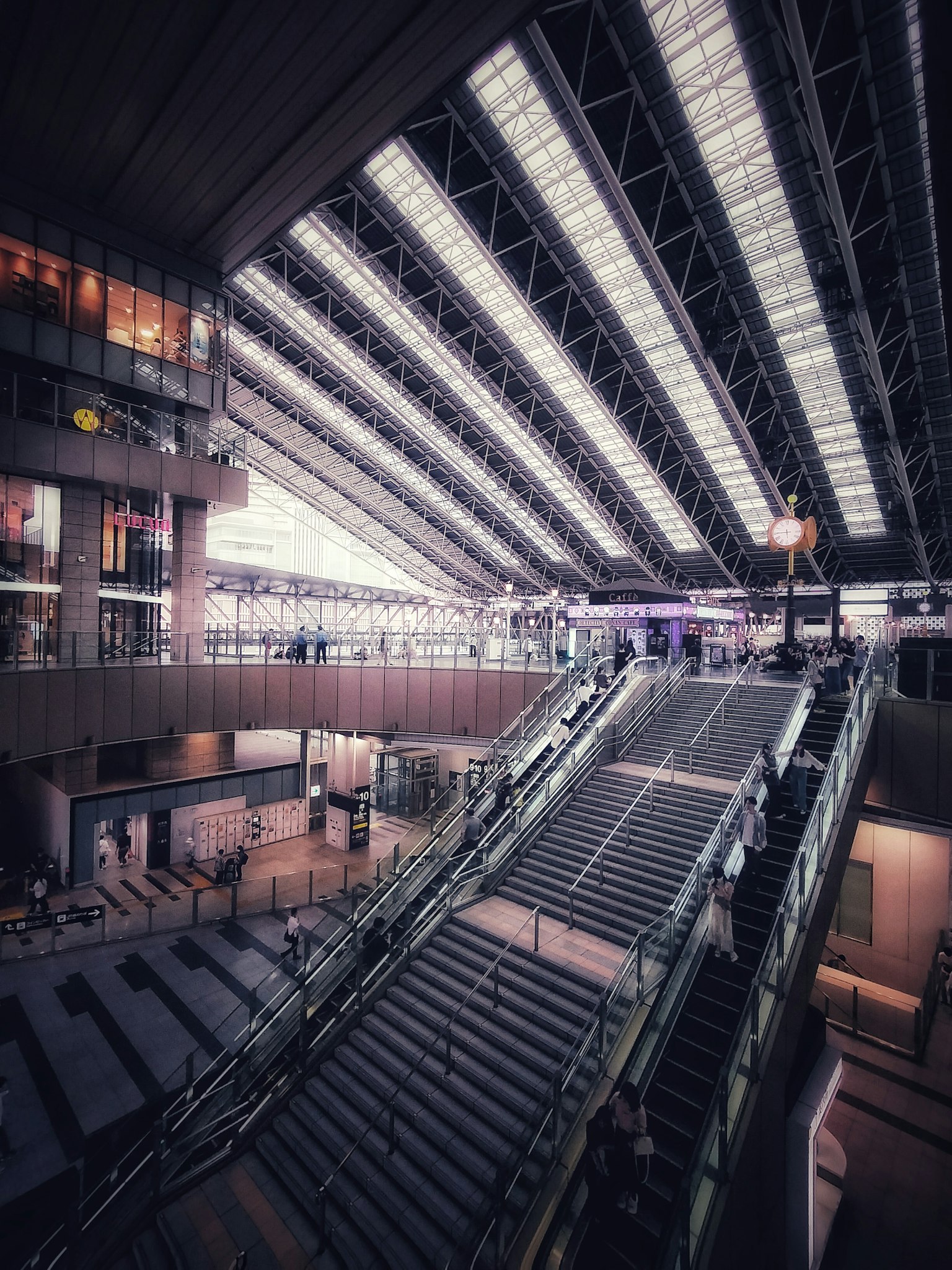Interior of a modern architectural space featuring large stairs and a glass roof