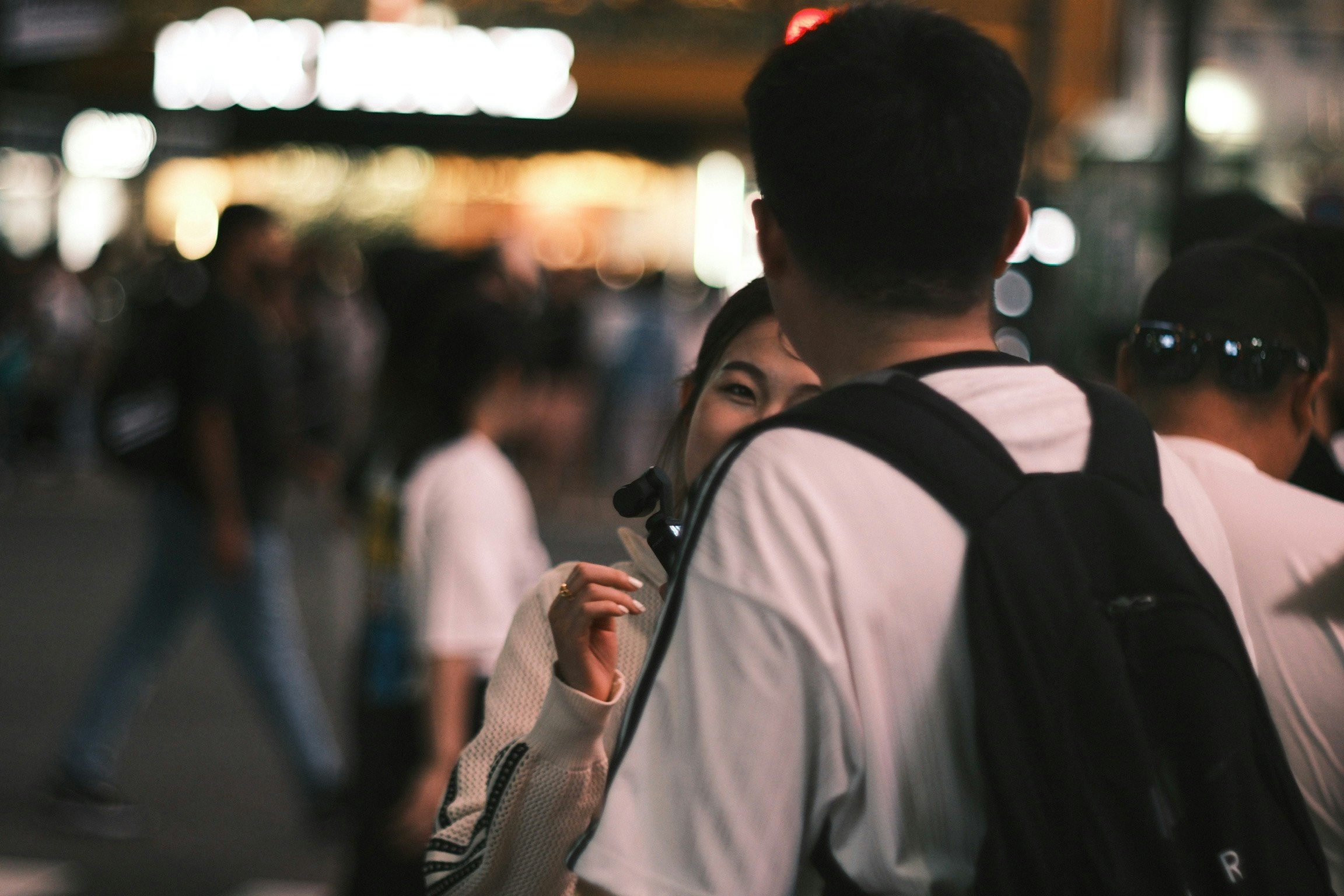 ảnh chụp nhanh ban đêm trên đường phố, mọi người đi với lưng quay về