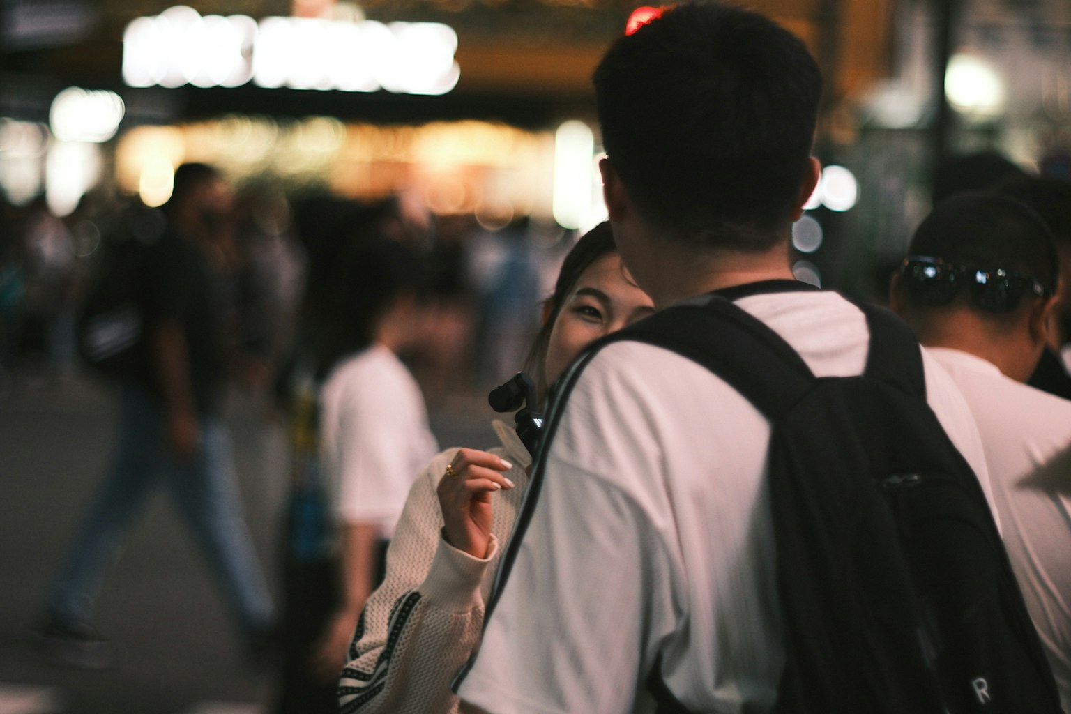 在繁忙夜街中親密交談的情侶
