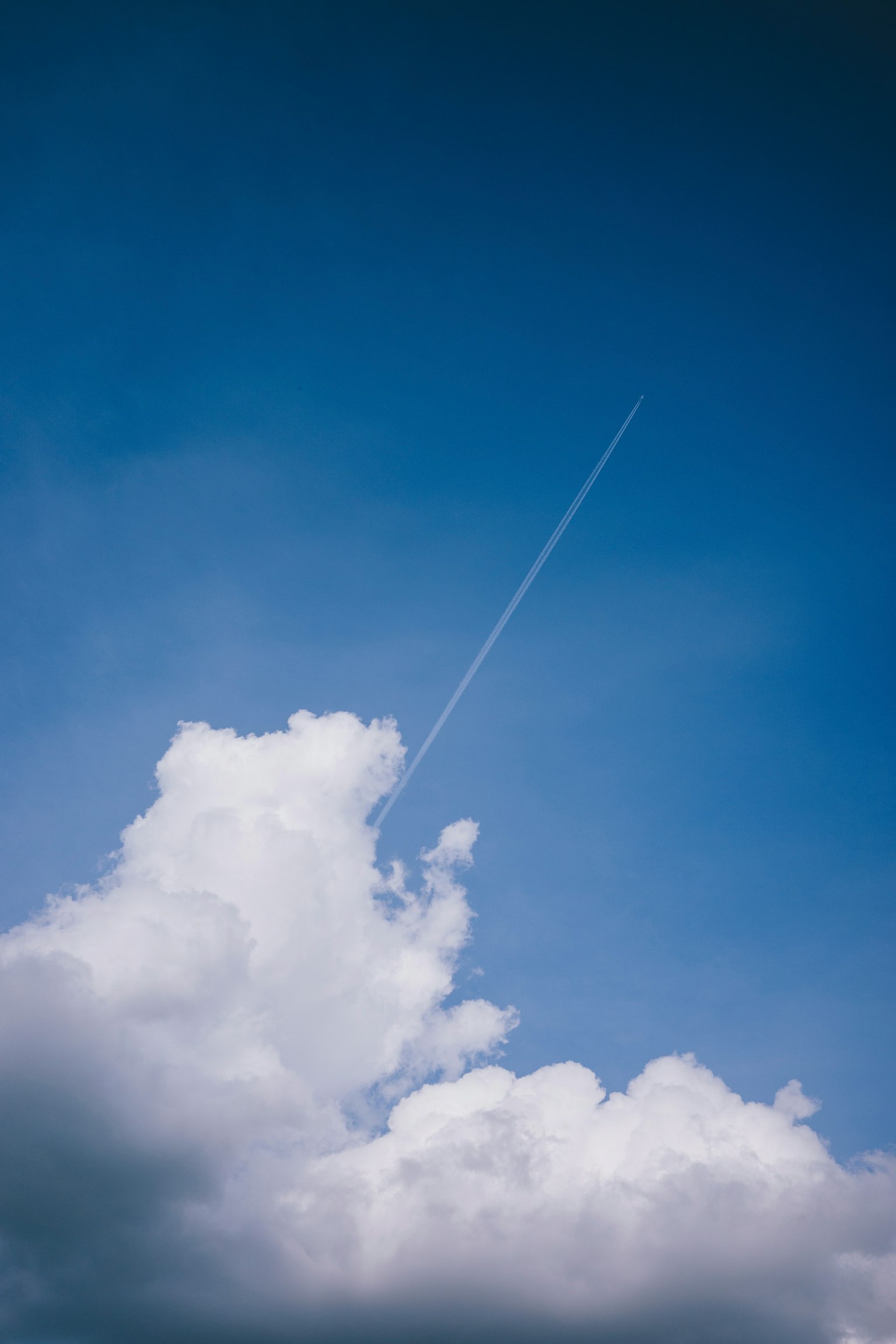 Langit dengan awan putih dan jejak pesawat