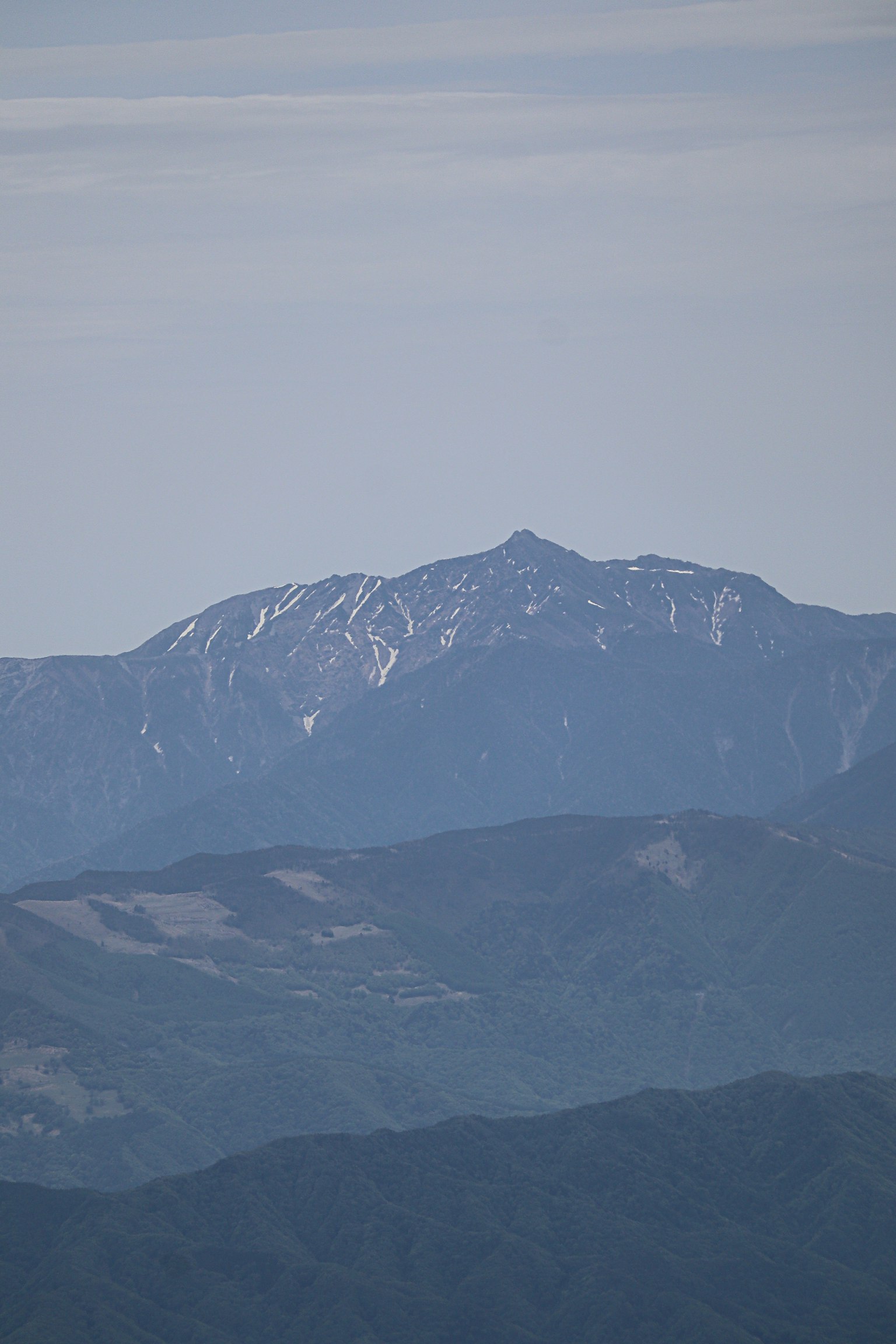 Vue lointaine d'une montagne enneigée sous un ciel bleu