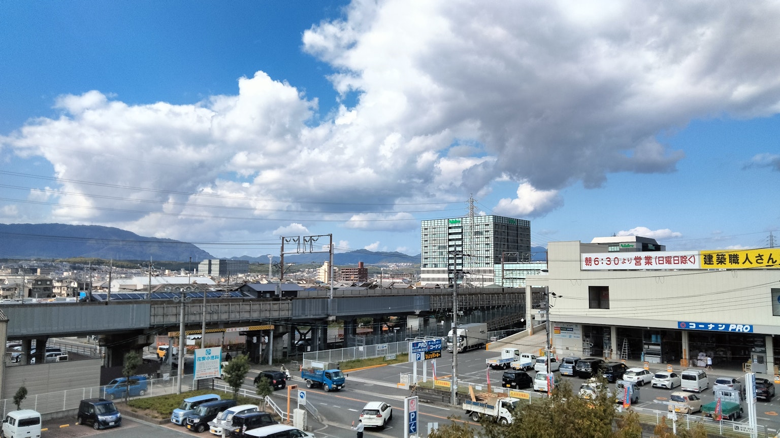 Paisaje urbano con cielo azul y nubes que presenta edificios y tráfico