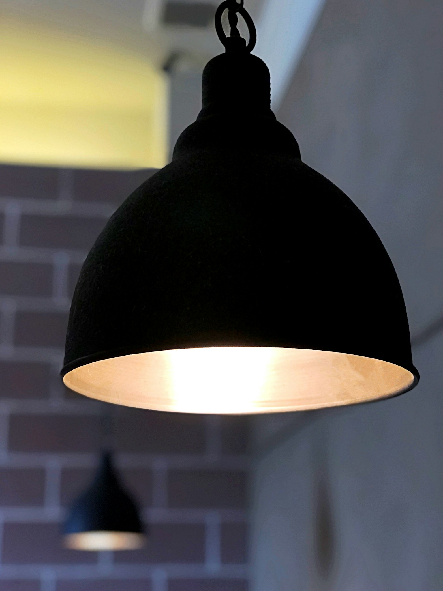 Lampada a sospensione nera che illumina lo spazio