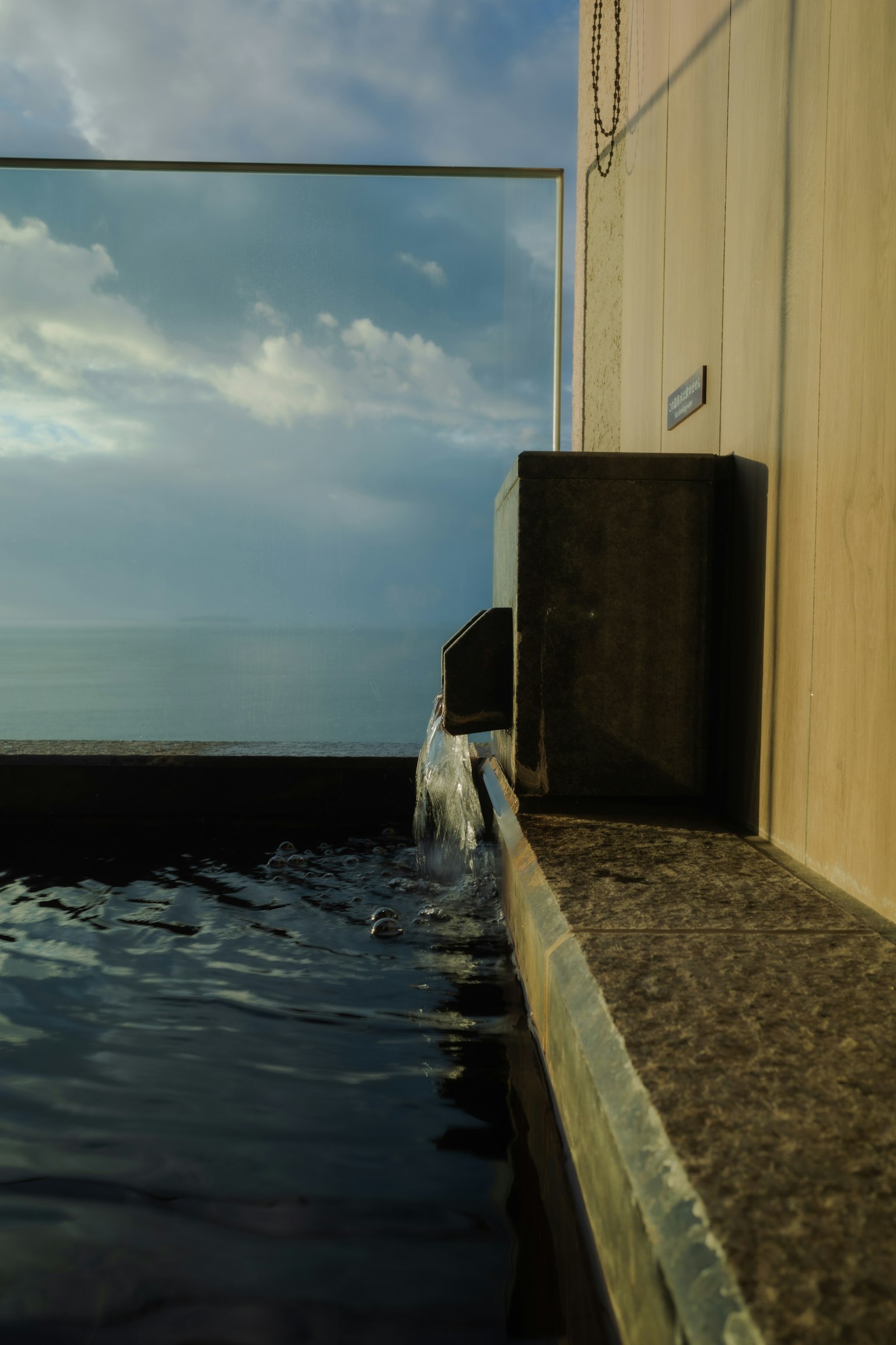 無邊泳池邊緣，水流與背景中的海洋景色