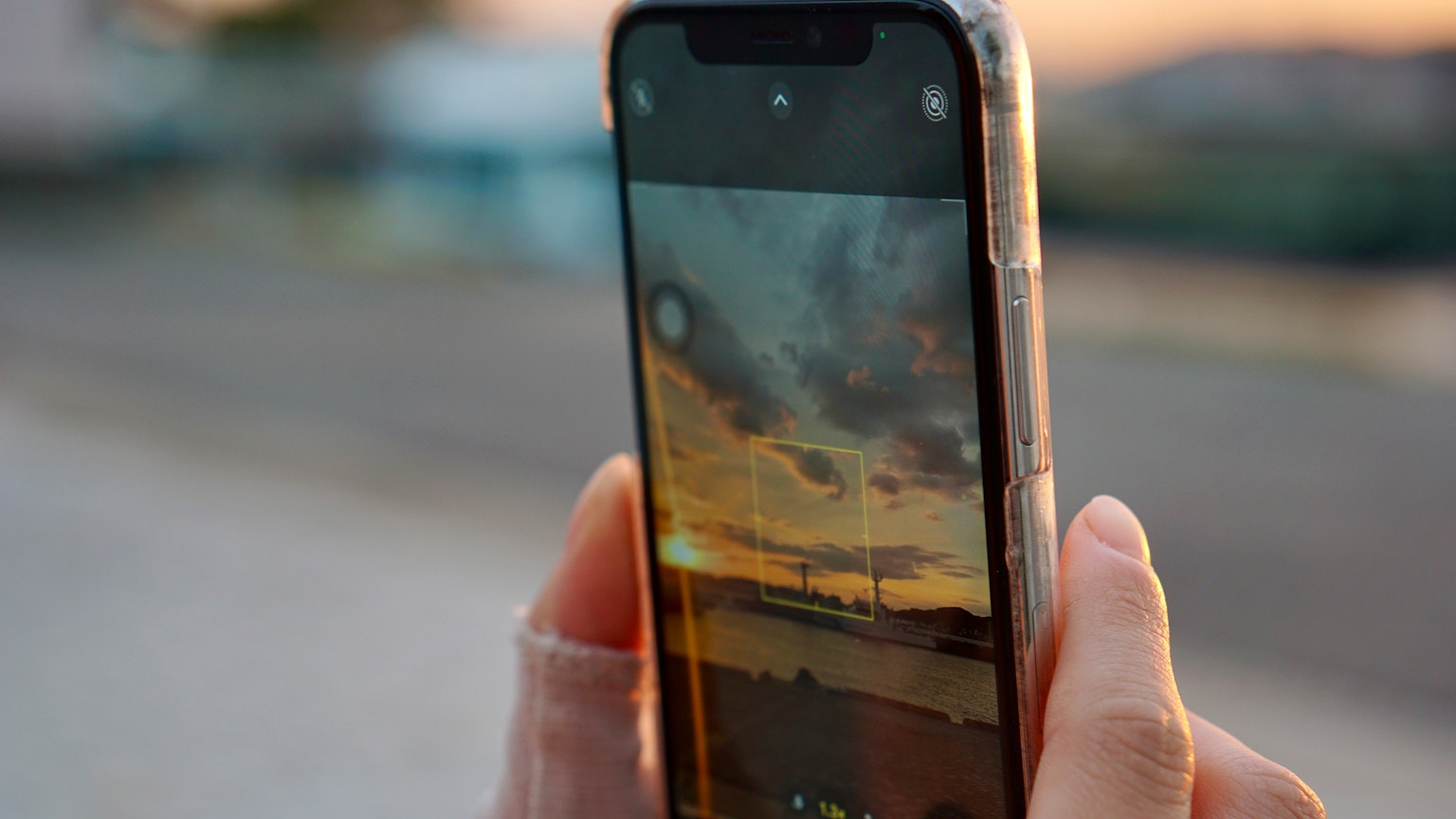 Nahaufnahme eines Smartphones, das einen Sonnenuntergang aufnimmt
