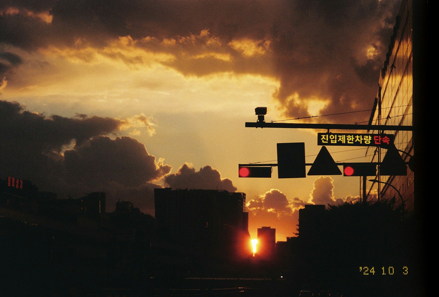 Silhouette di una città con segnali stradali contro uno sfondo di tramonto