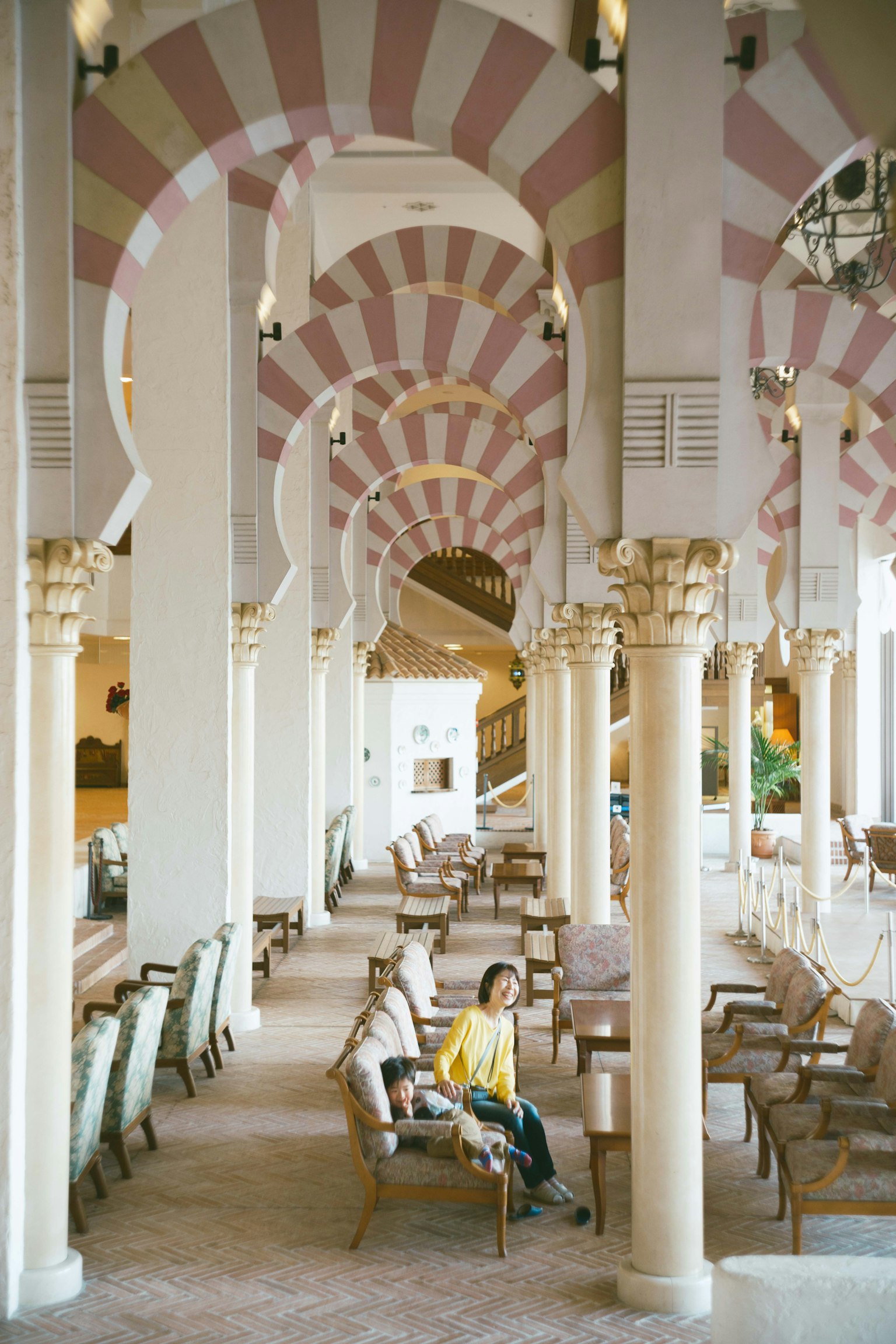 Spacious lobby featuring beautiful arch-shaped ceilings and columns with people seated