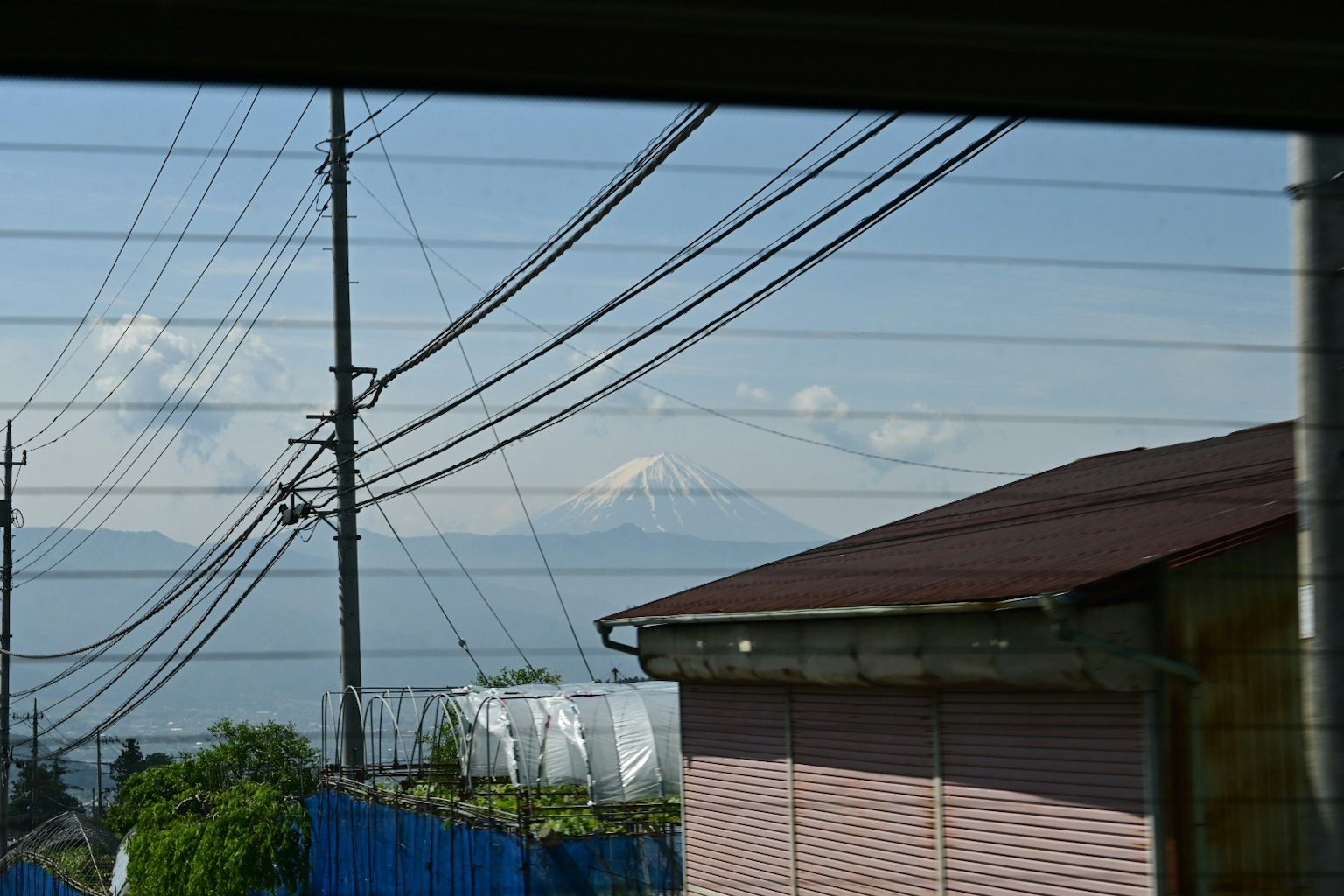 Vista de montañas y líneas eléctricas a través de una ventana