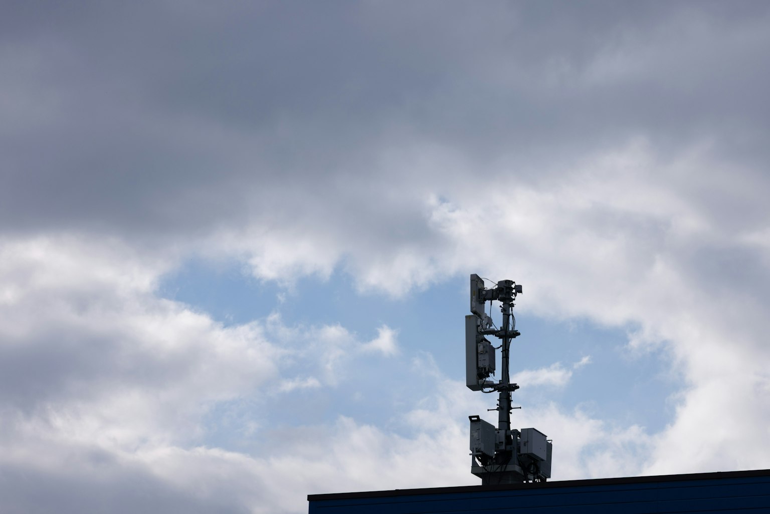 雲和藍天背景下的通信塔上部