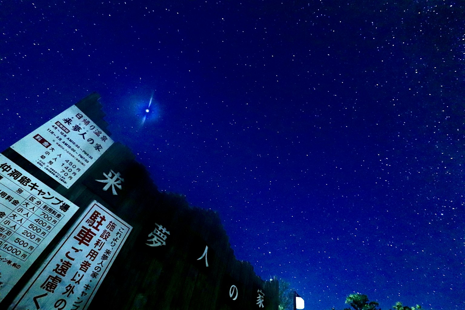 Señales japonesas bajo un cielo estrellado con estrellas brillantes