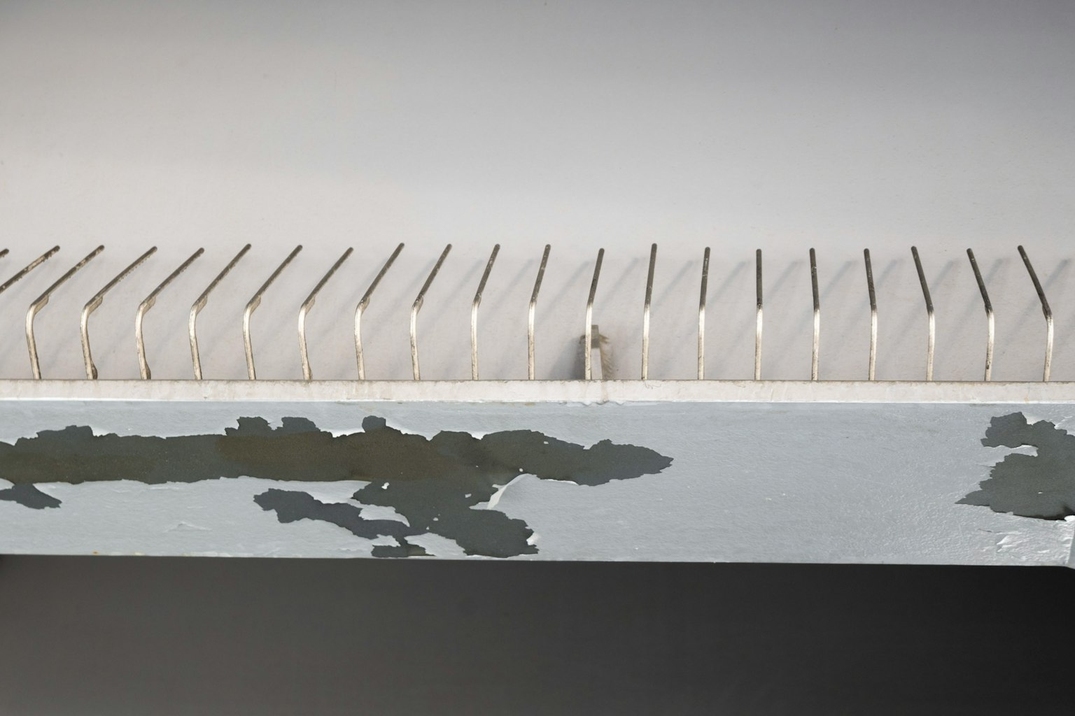 Un oggetto dal design semplice con una fila di dorsi di libri su una superficie bianca