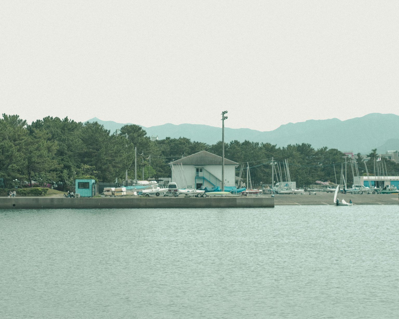 水边的白色建筑和船只的风景，背景是山