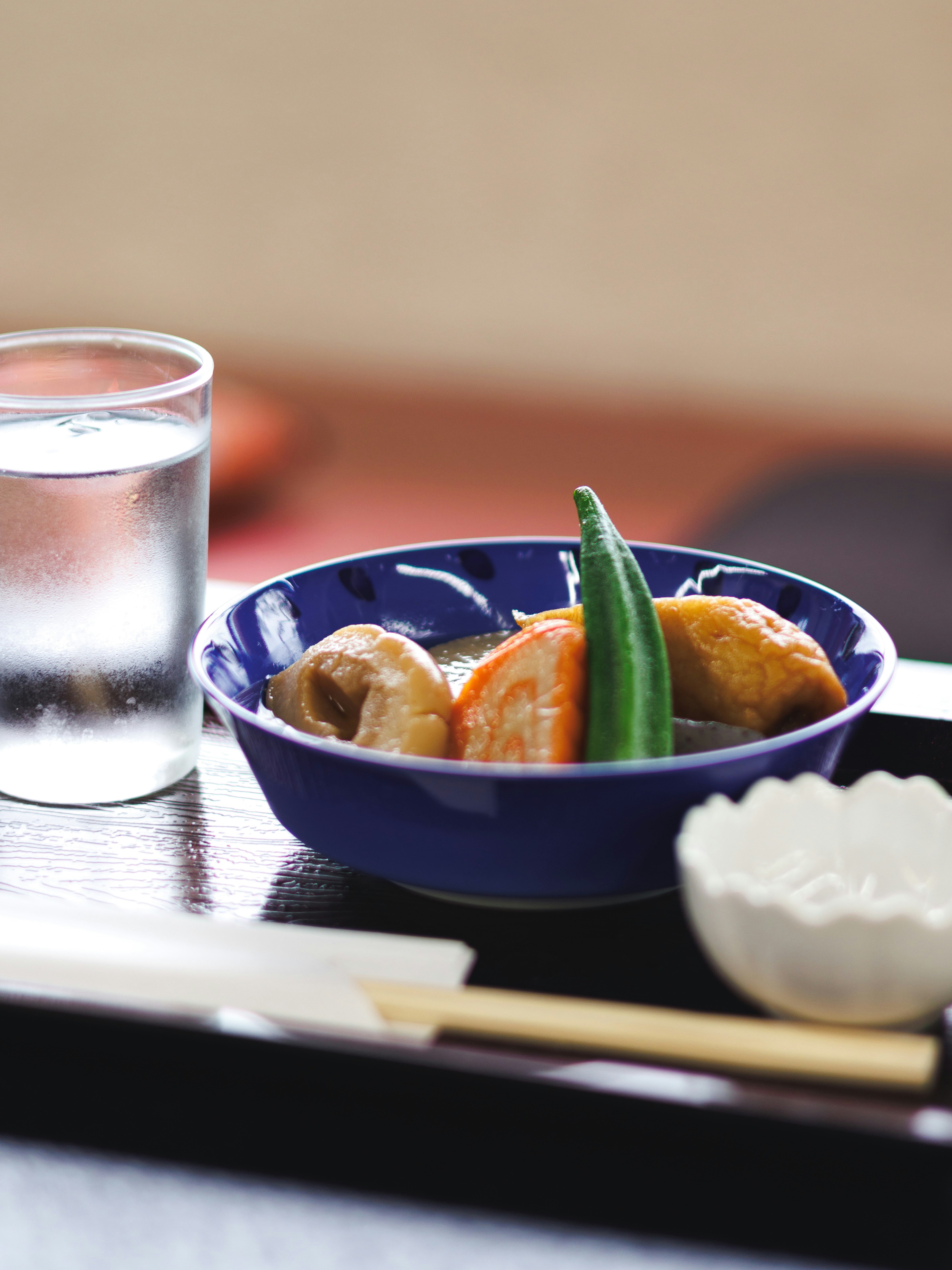 青い器に盛られた煮込み料理と青唐辛子