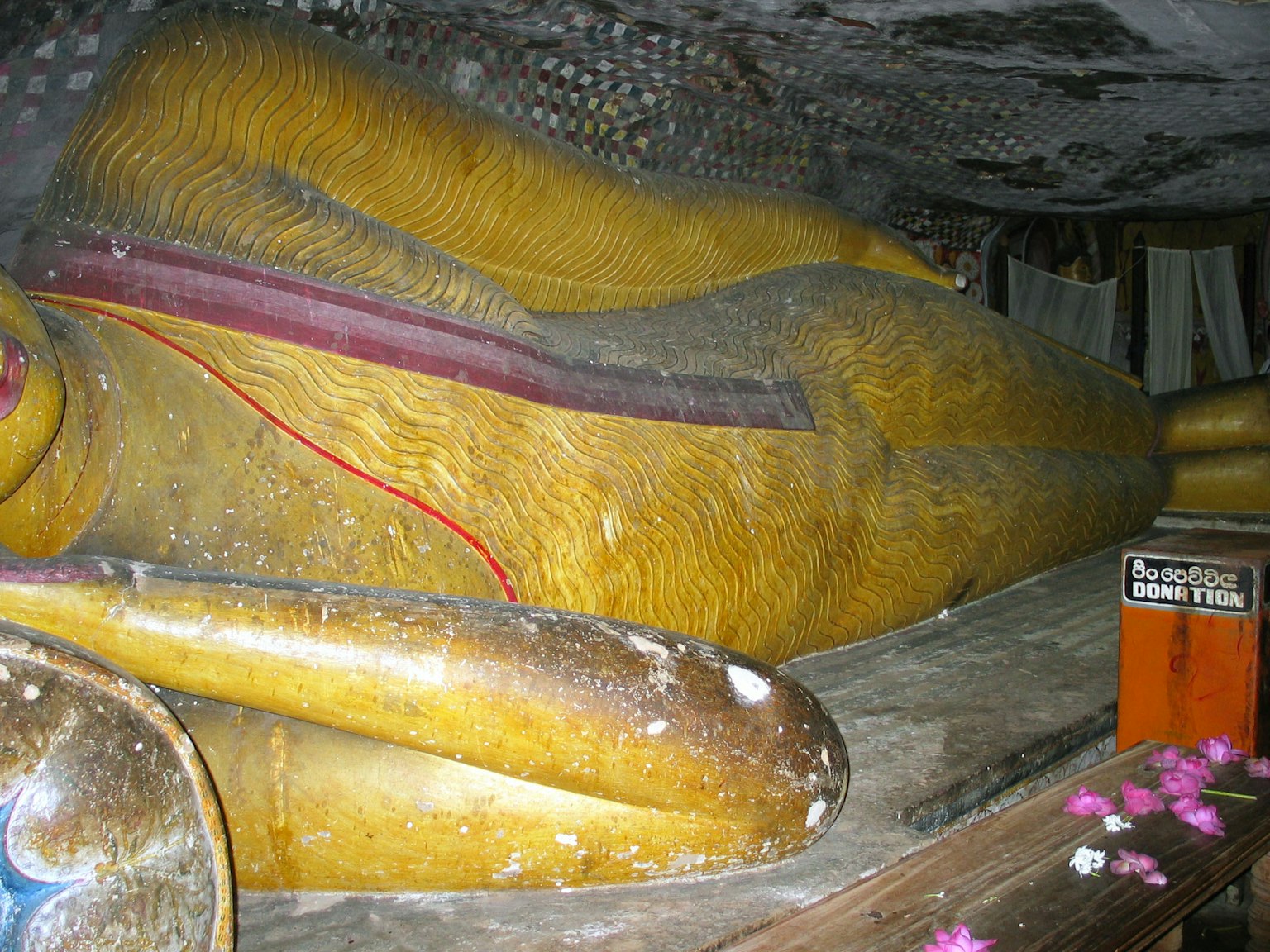 Golden reclining Buddha statue lying in a cave
