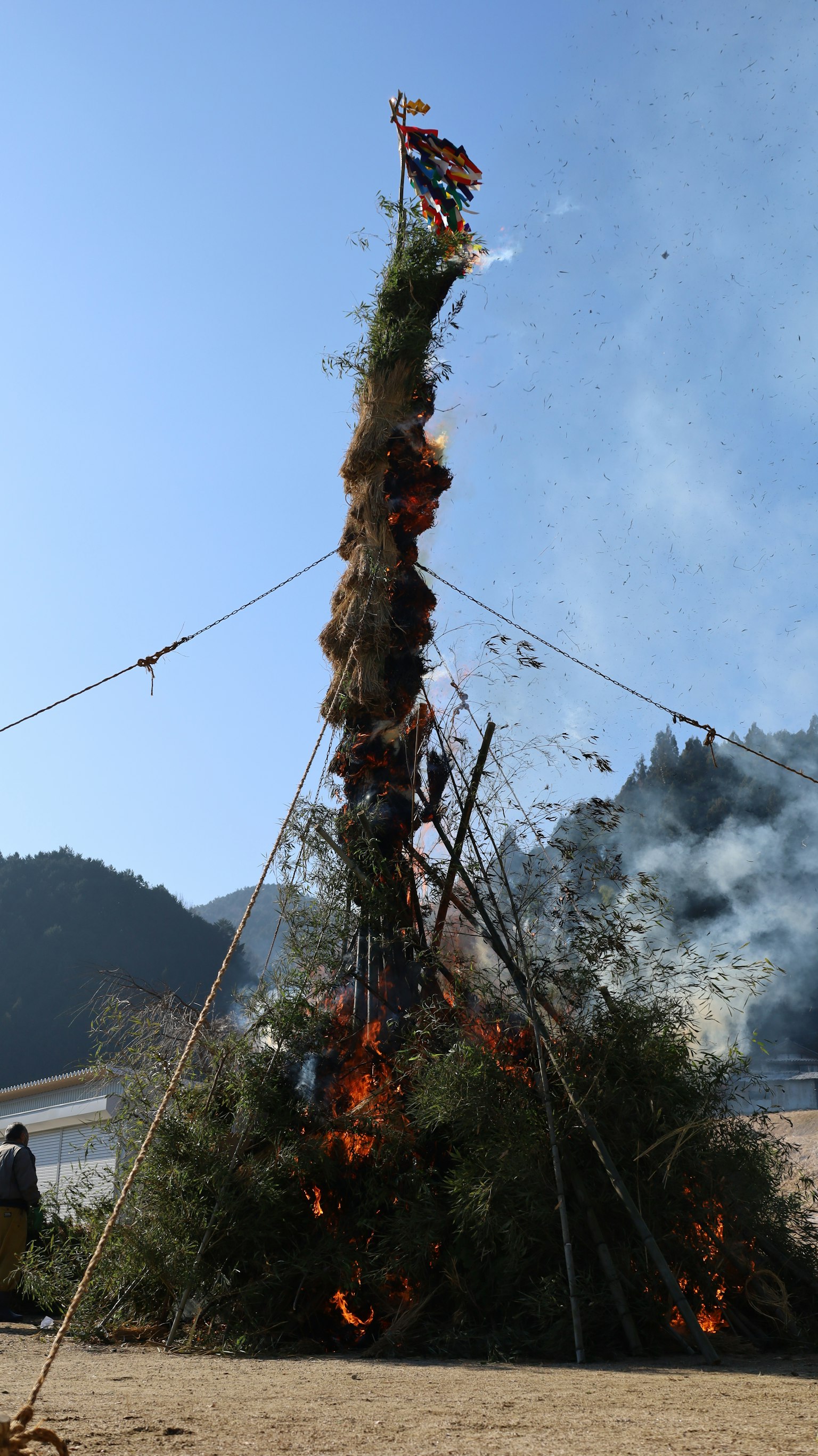 Ein hoher brennender Turm aus Grün und Holz