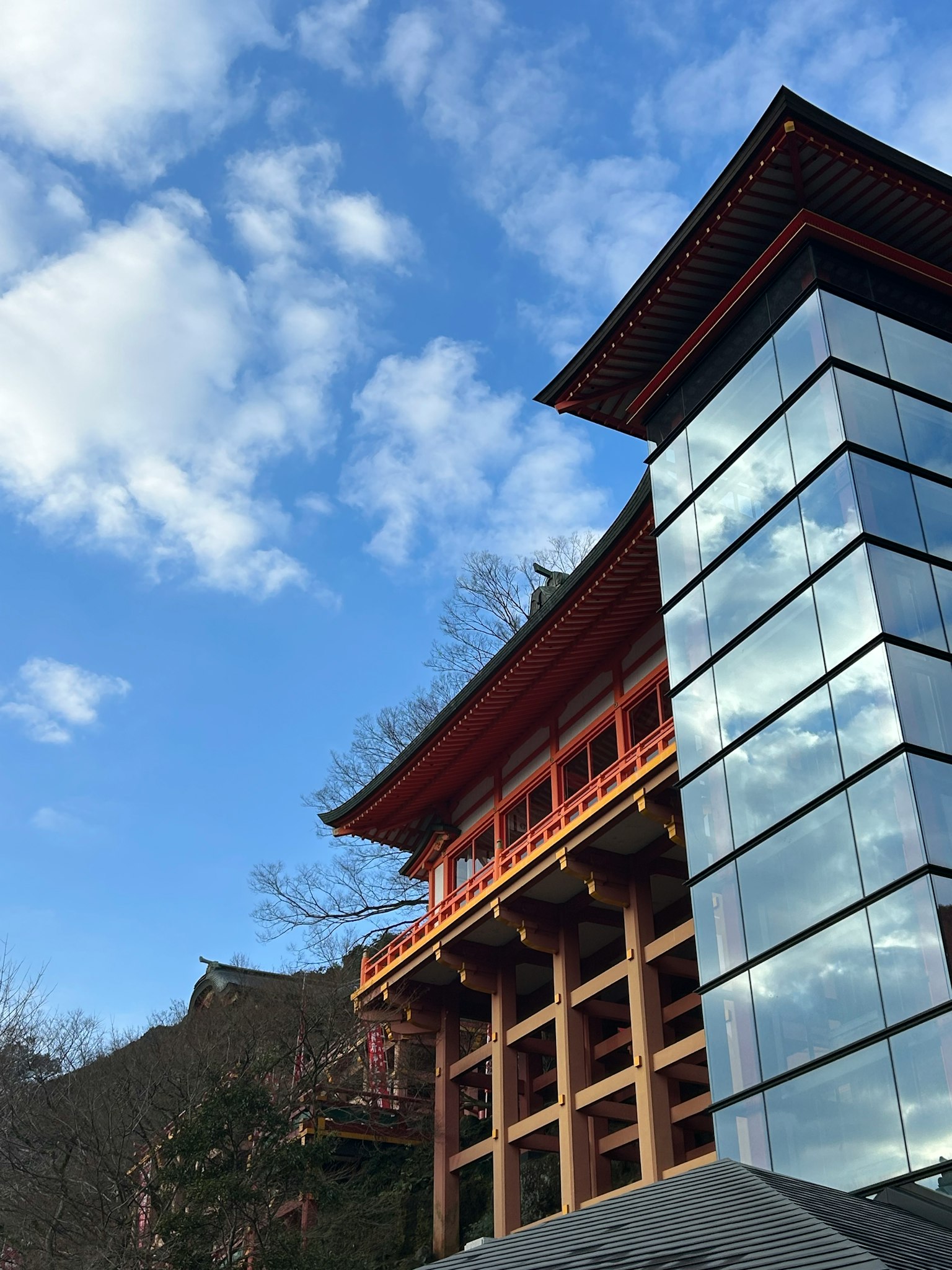 Traditional red building combined with modern glass structure under a blue sky